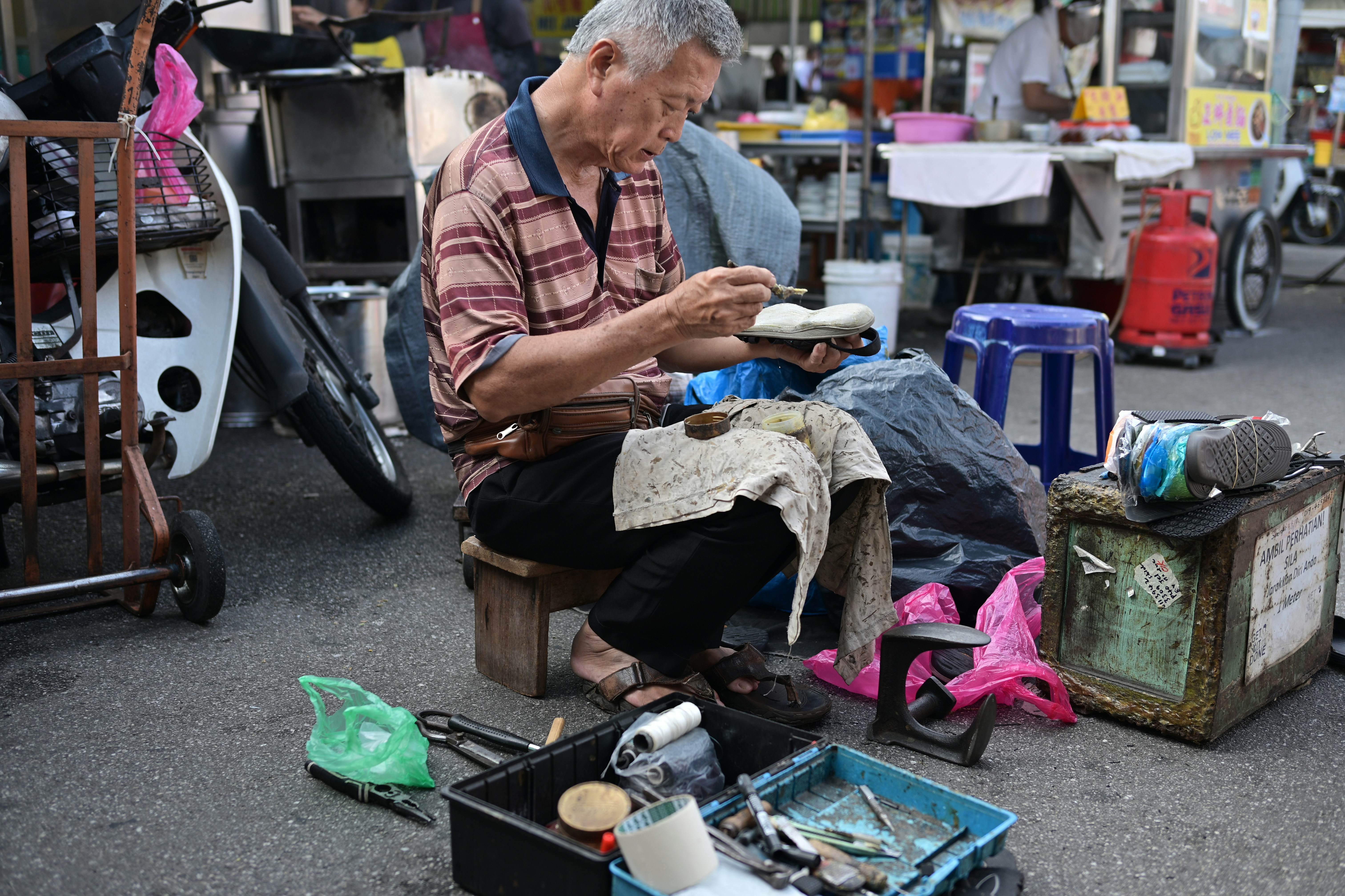 a cobbler working on a complex shoe repair - fix shoe lining disintegrating