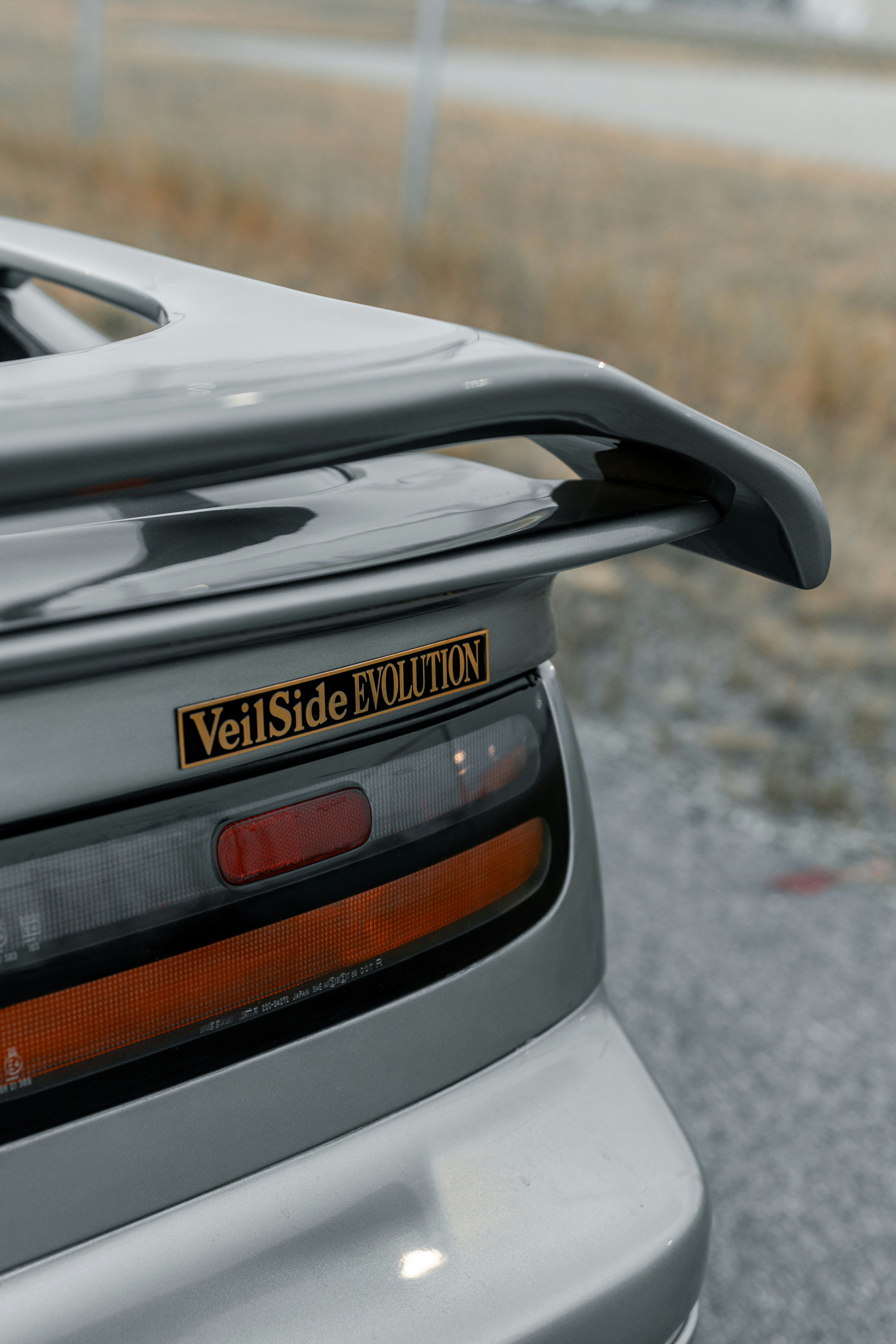 A gray sports car's rear tail light.