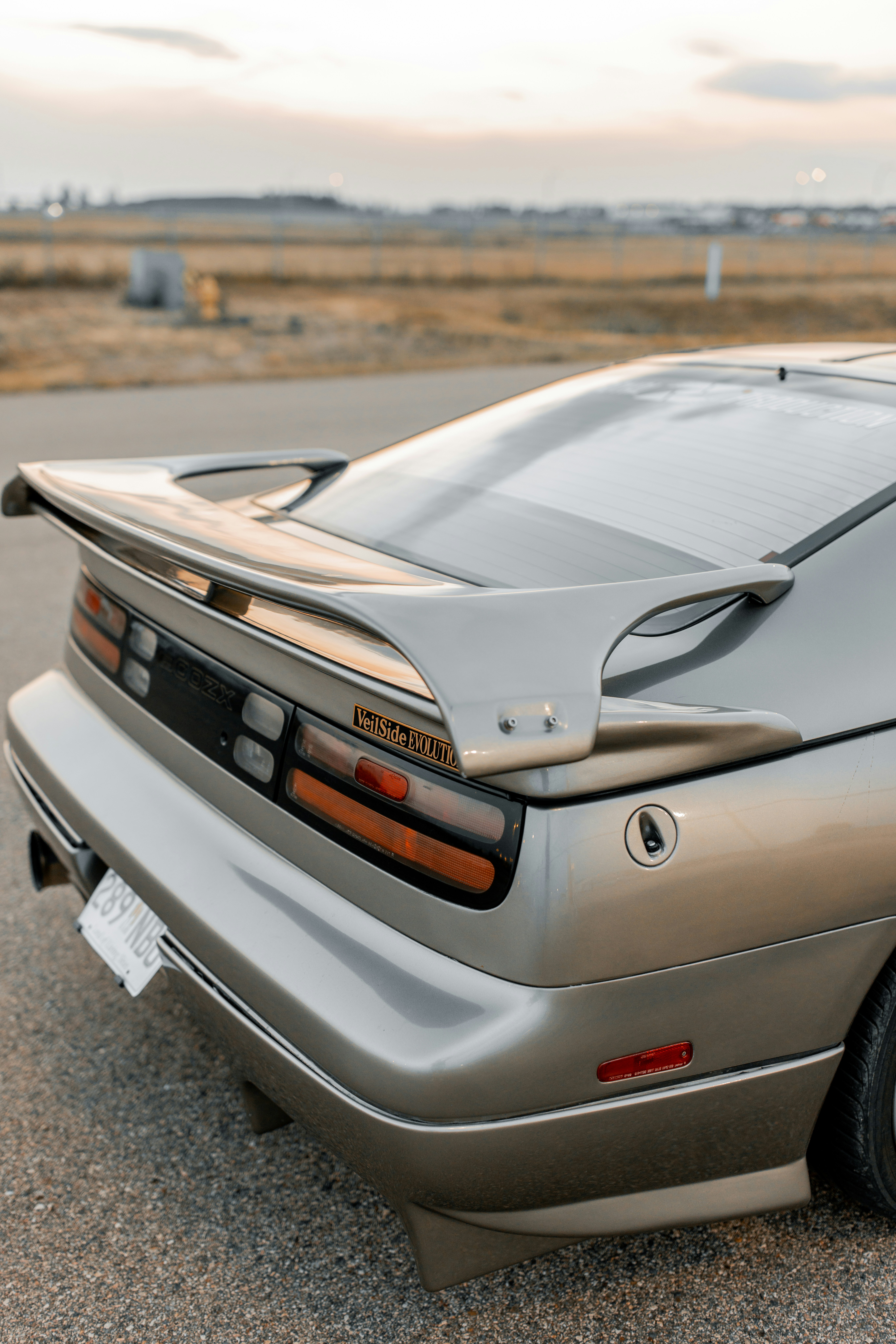 A silver sports car's rear view is shown.