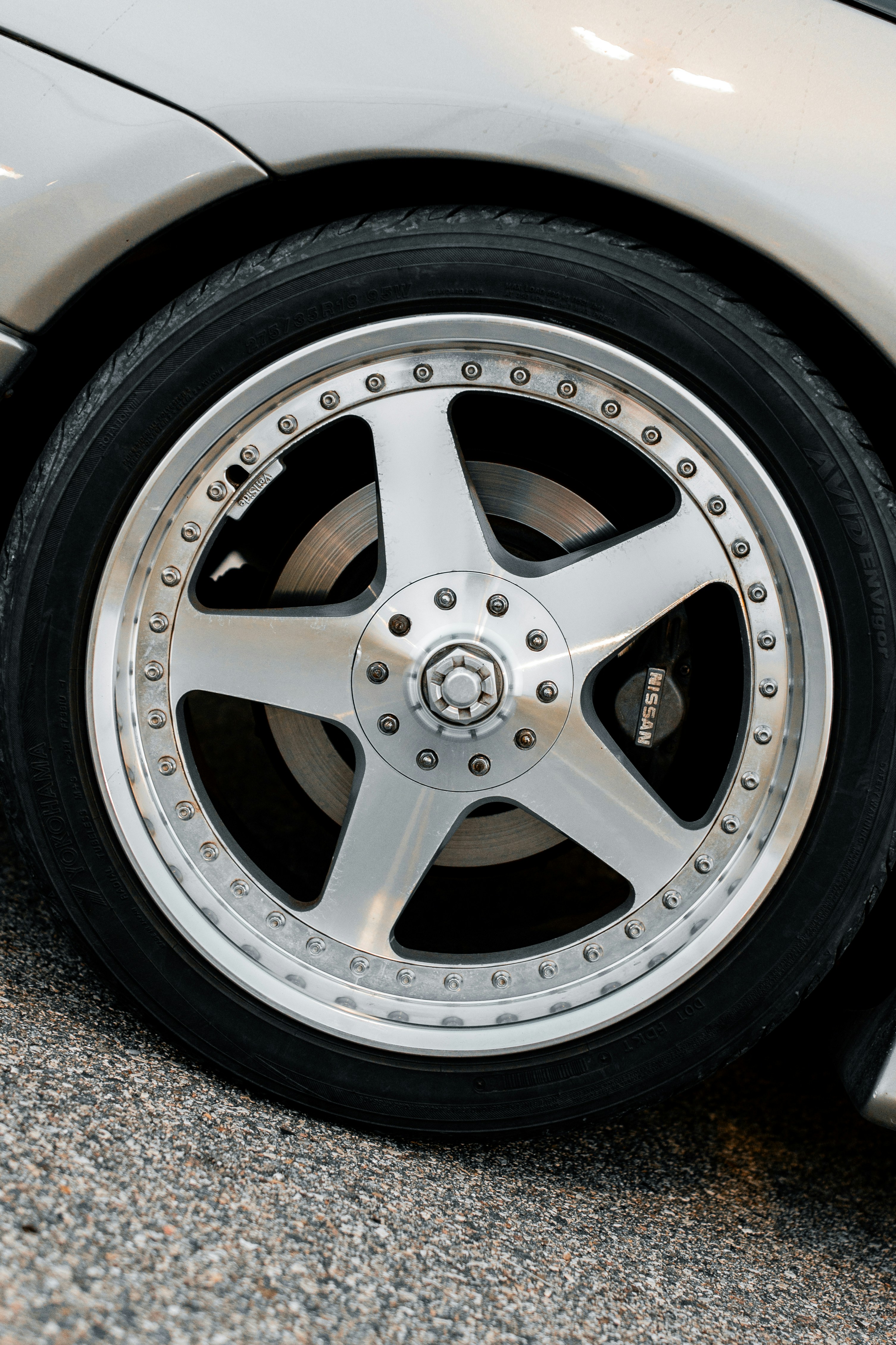 A silver car wheel is shown in close-up.