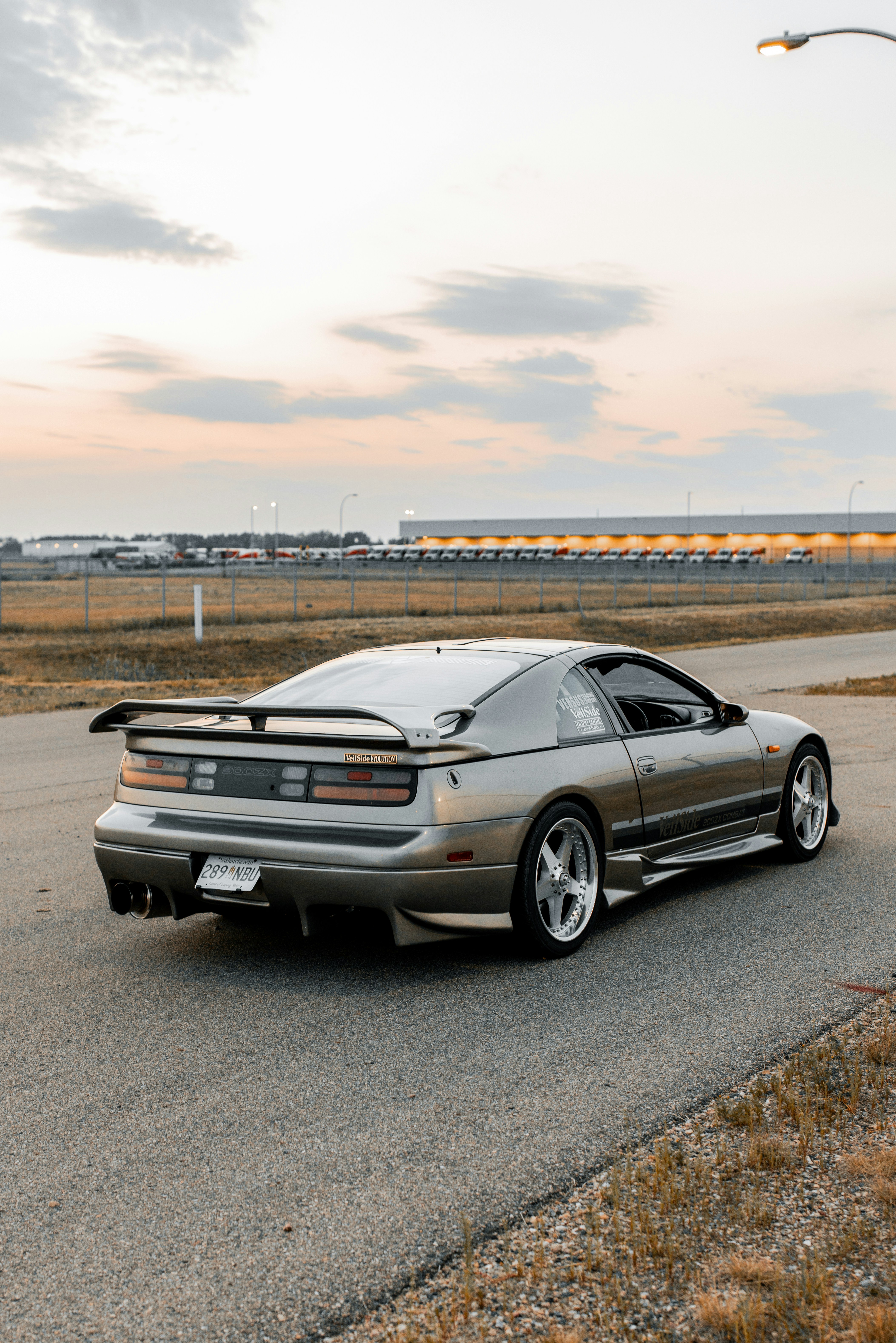 A silver sports car is parked on a road.