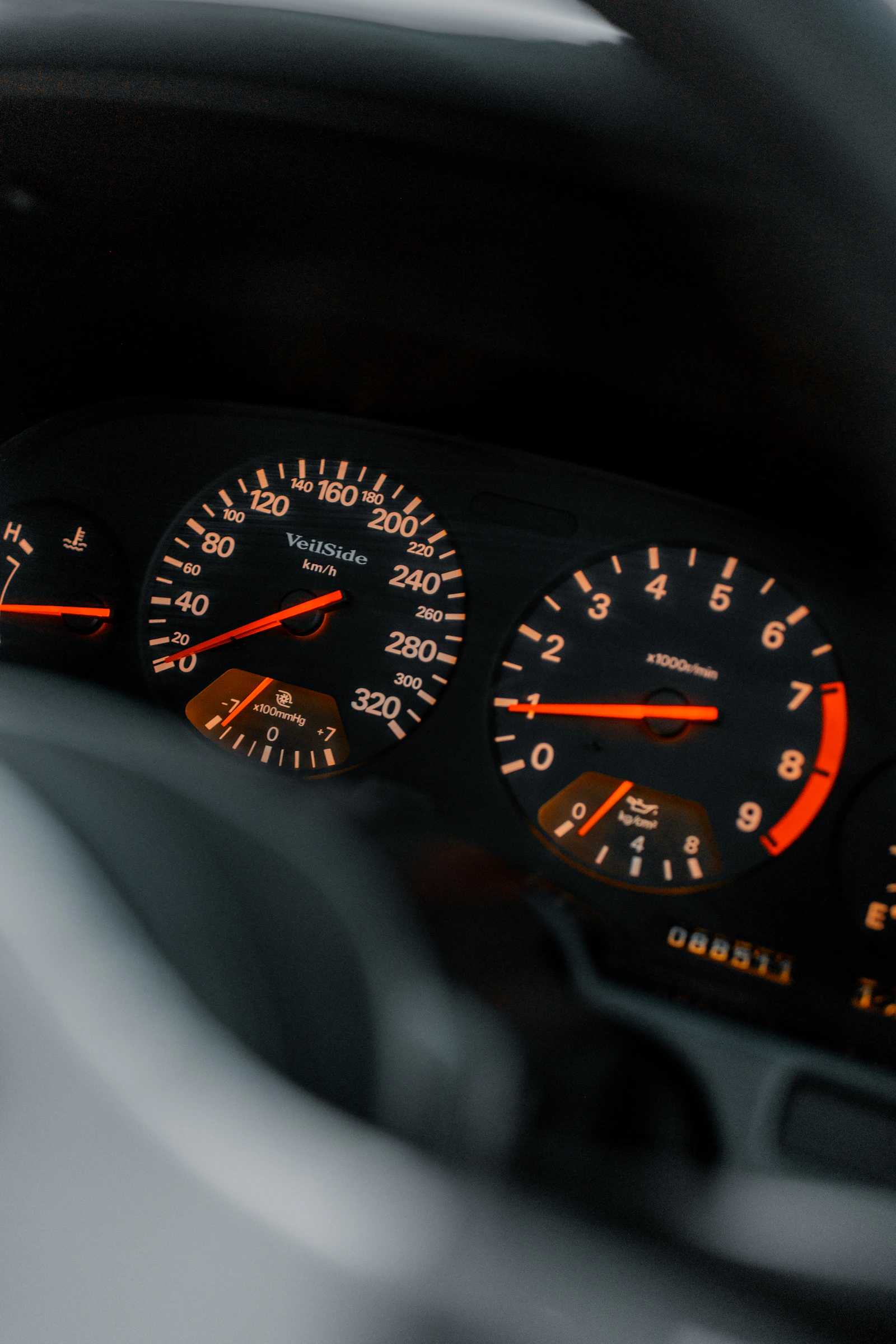 Close-up of a car dashboard showing a speedometer and tachometer side by side