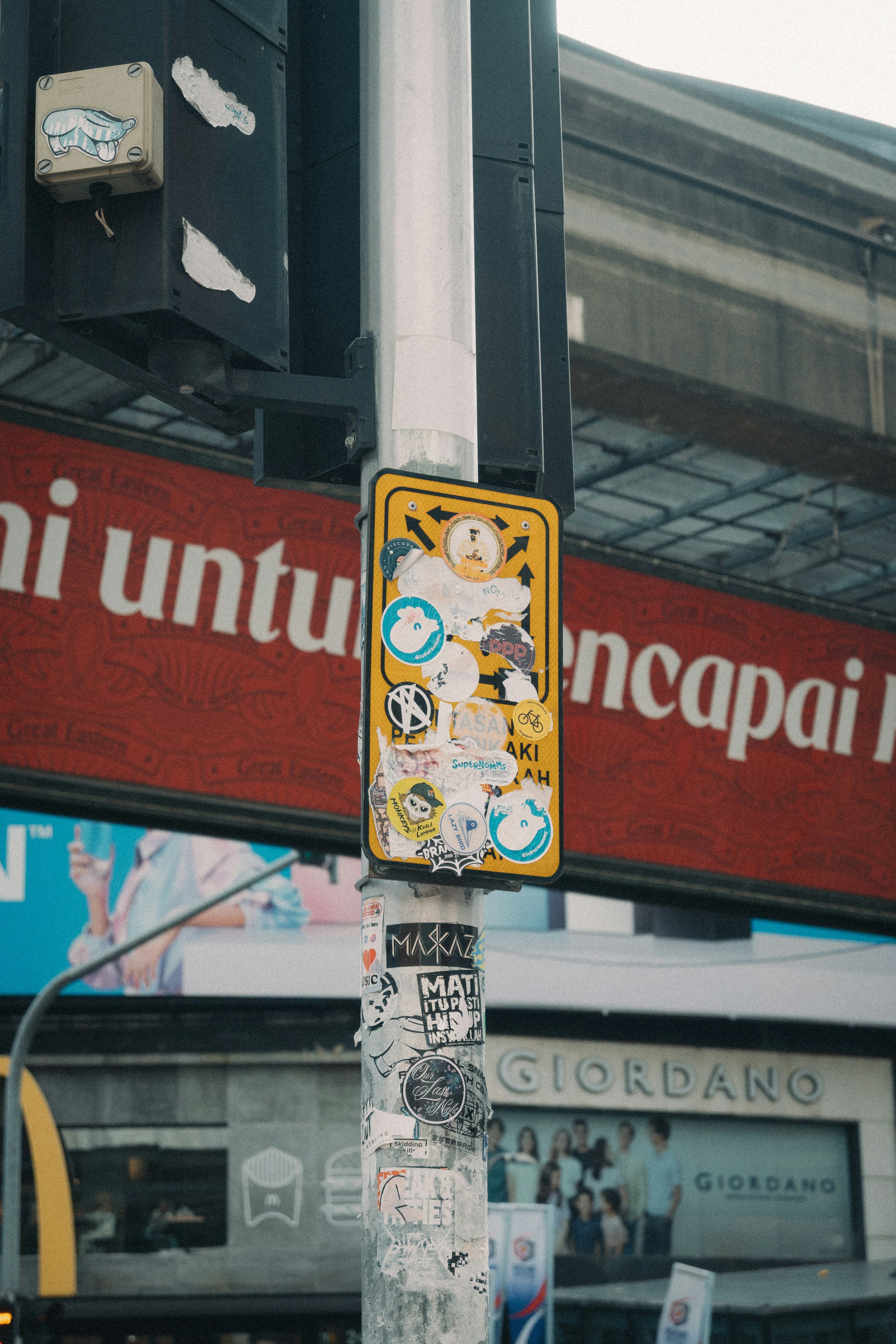 A street post covered in stickers stands tall.