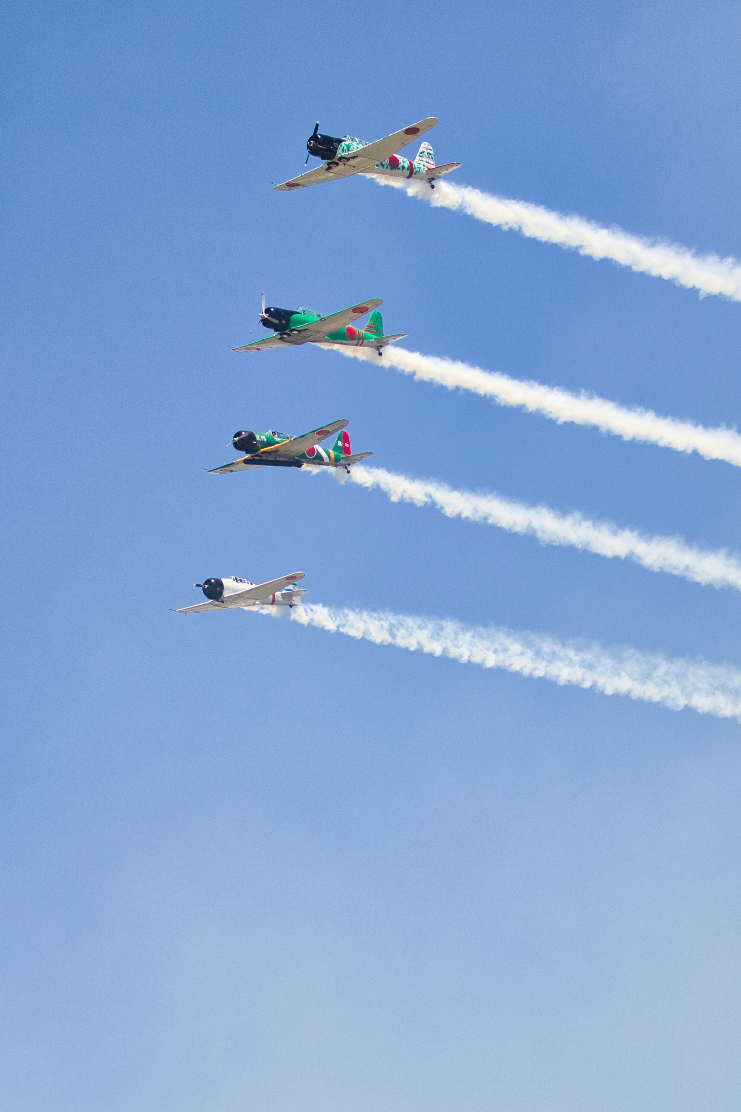 Aviões realizando uma exibição de vôo acrobático com rastros de fumaça.