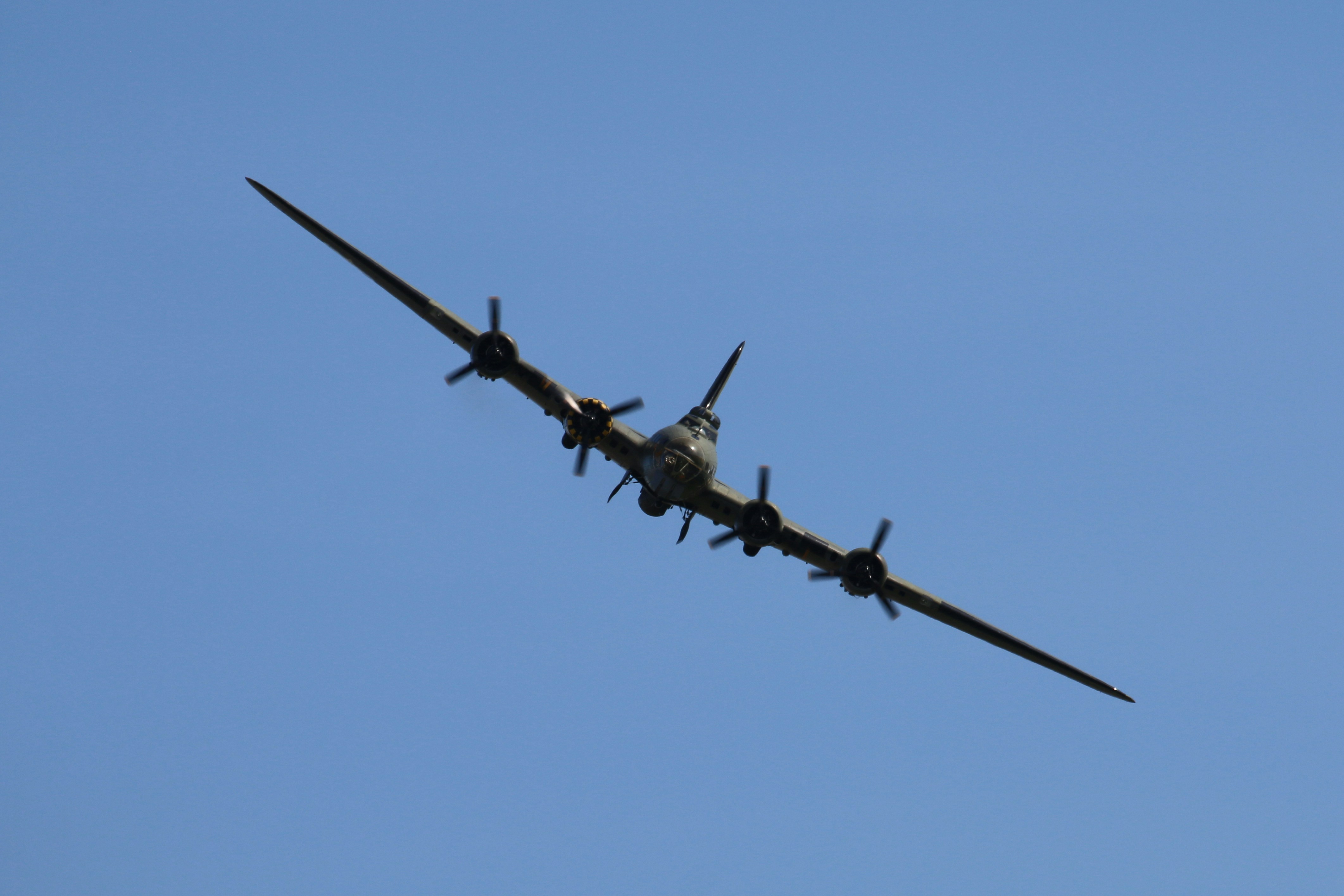 Ein Oldtimer-Flugzeug fliegt durch den klaren Himmel.