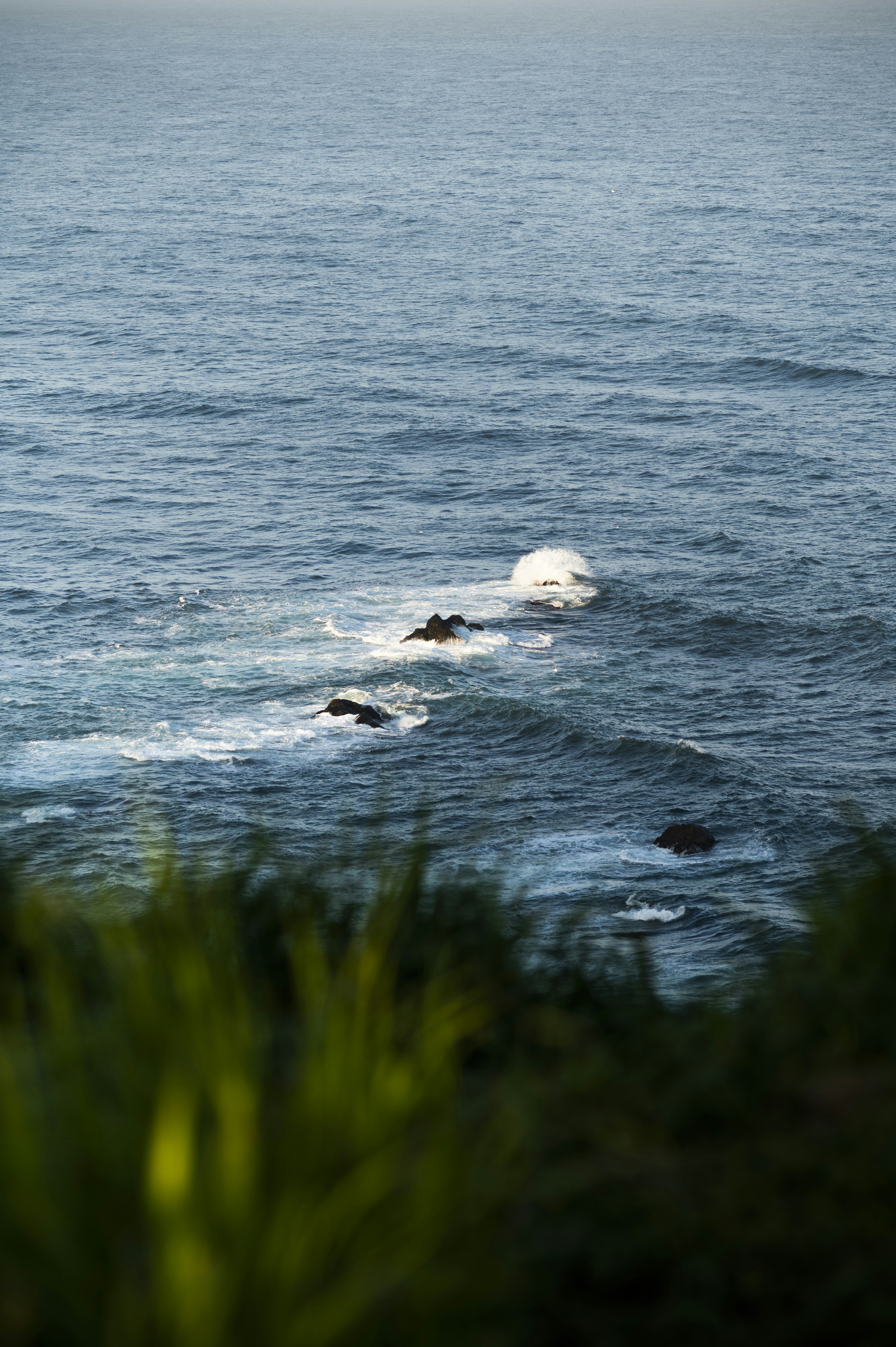 Waves crash against rocks in the ocean.
