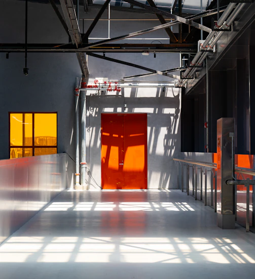 An industrial interior with orange accents and shadows