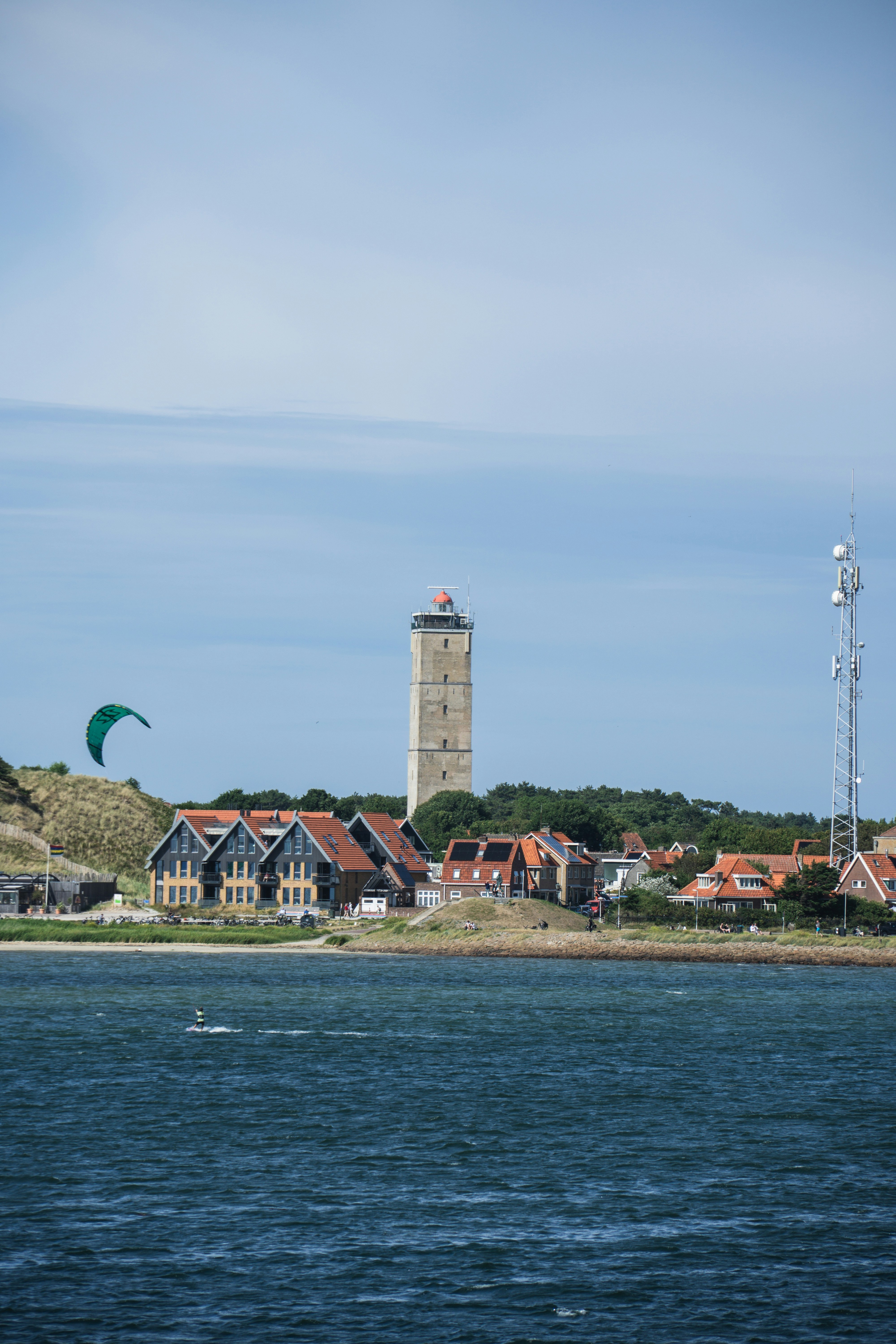 Ein Leuchtturm thront über einer Küstenstadt.