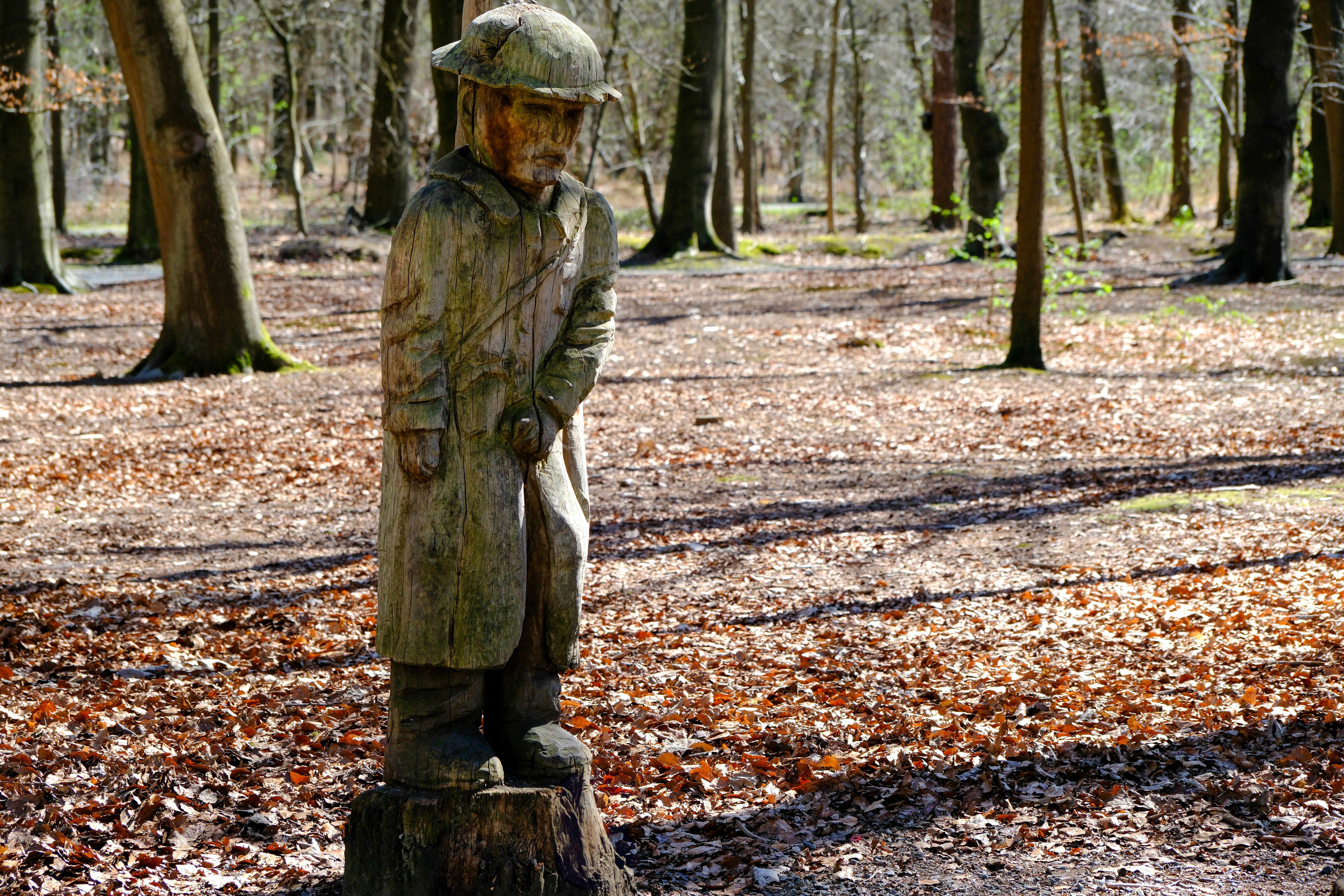 Eine Holzstatue steht im Wald.