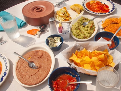 A table is spread with delicious mexican food.