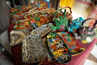 Handmade, colorful ceramics are displayed for sale.