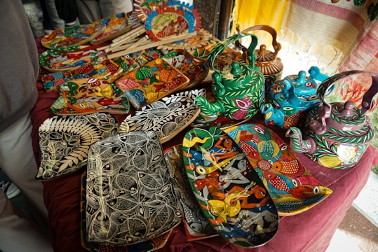 Handmade, colorful ceramics are displayed for sale.