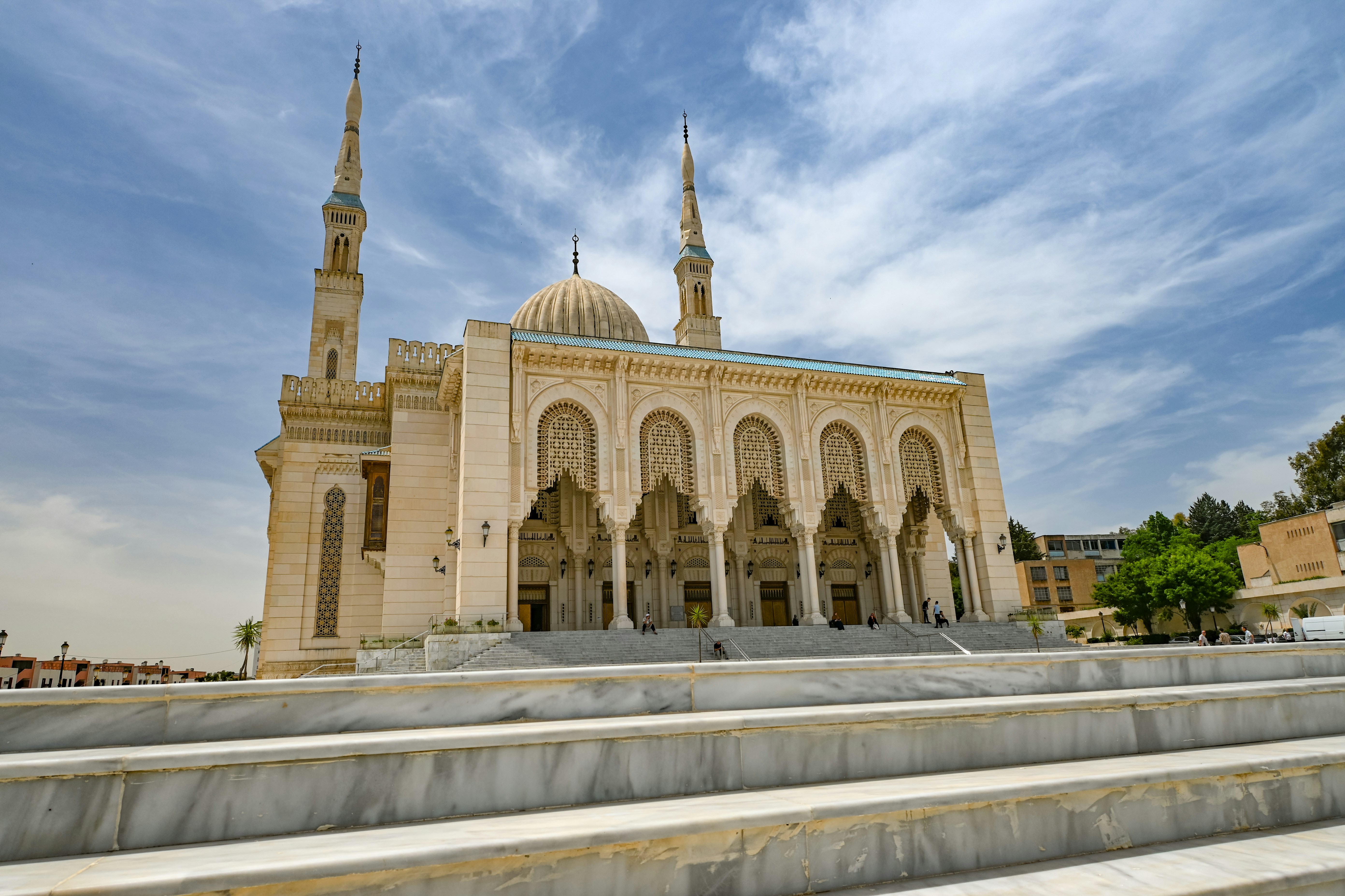 A beautiful mosque stands under a cloudy sky.