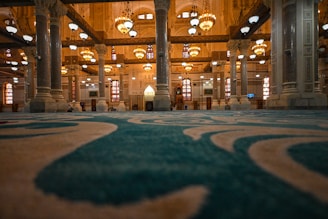 Inside a grand mosque with ornate architecture.