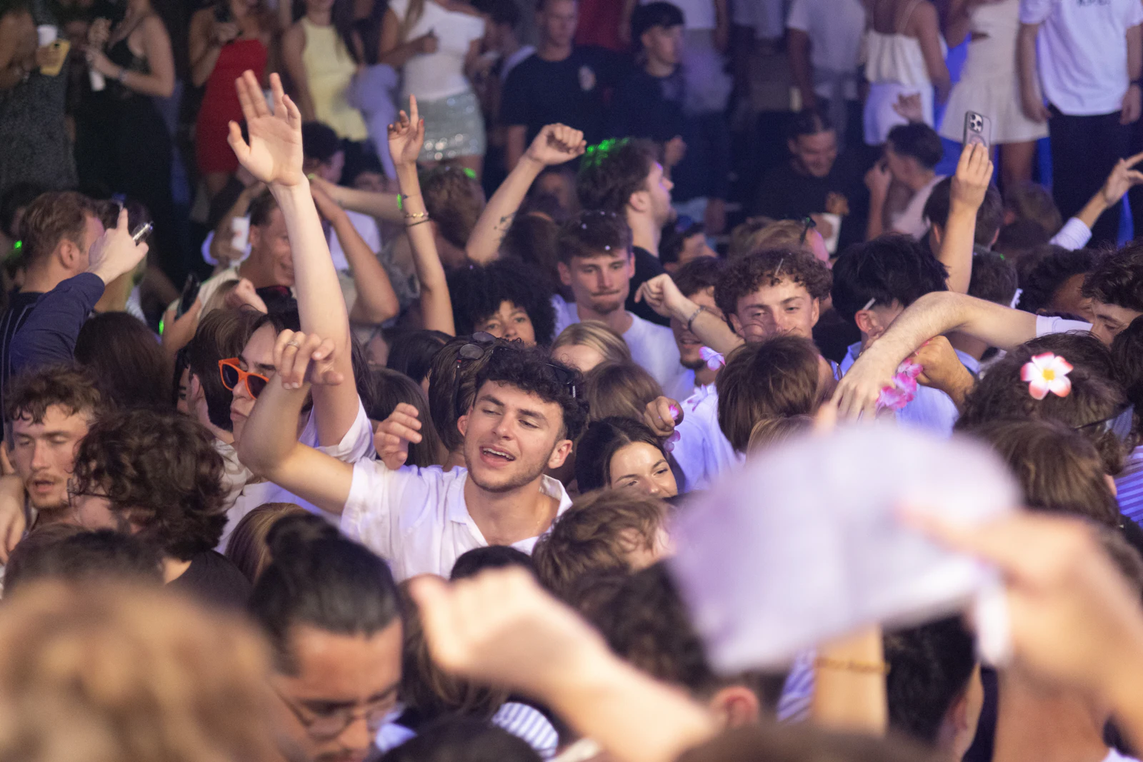 Packed crowd with their hands in the air