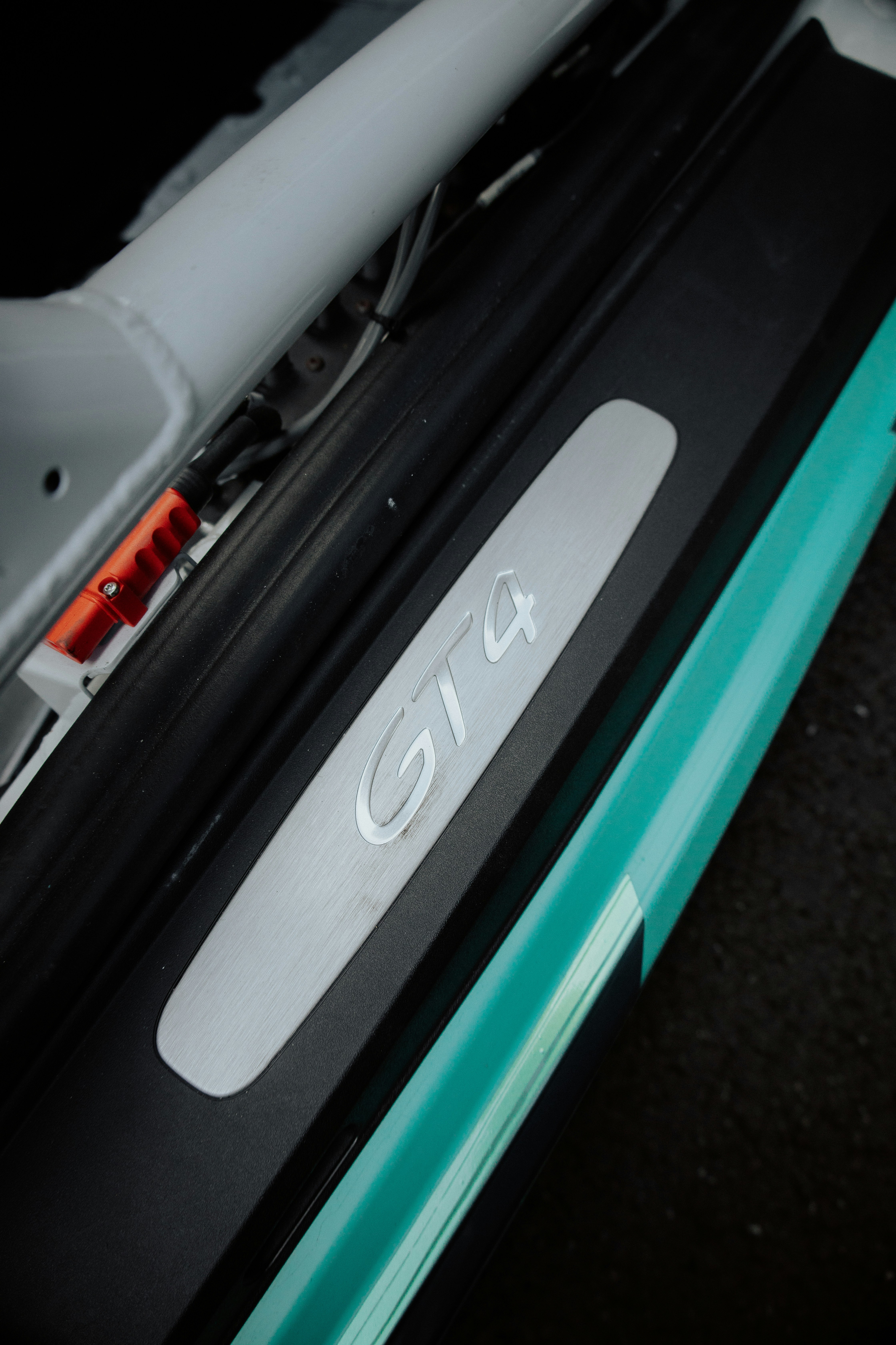 Soleira da porta de um carro com "gt4" exibido.