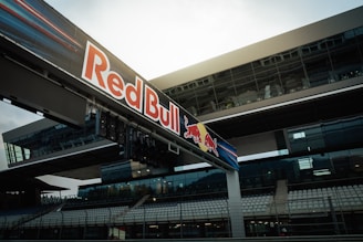 Red bull signage above a race track's grandstand.