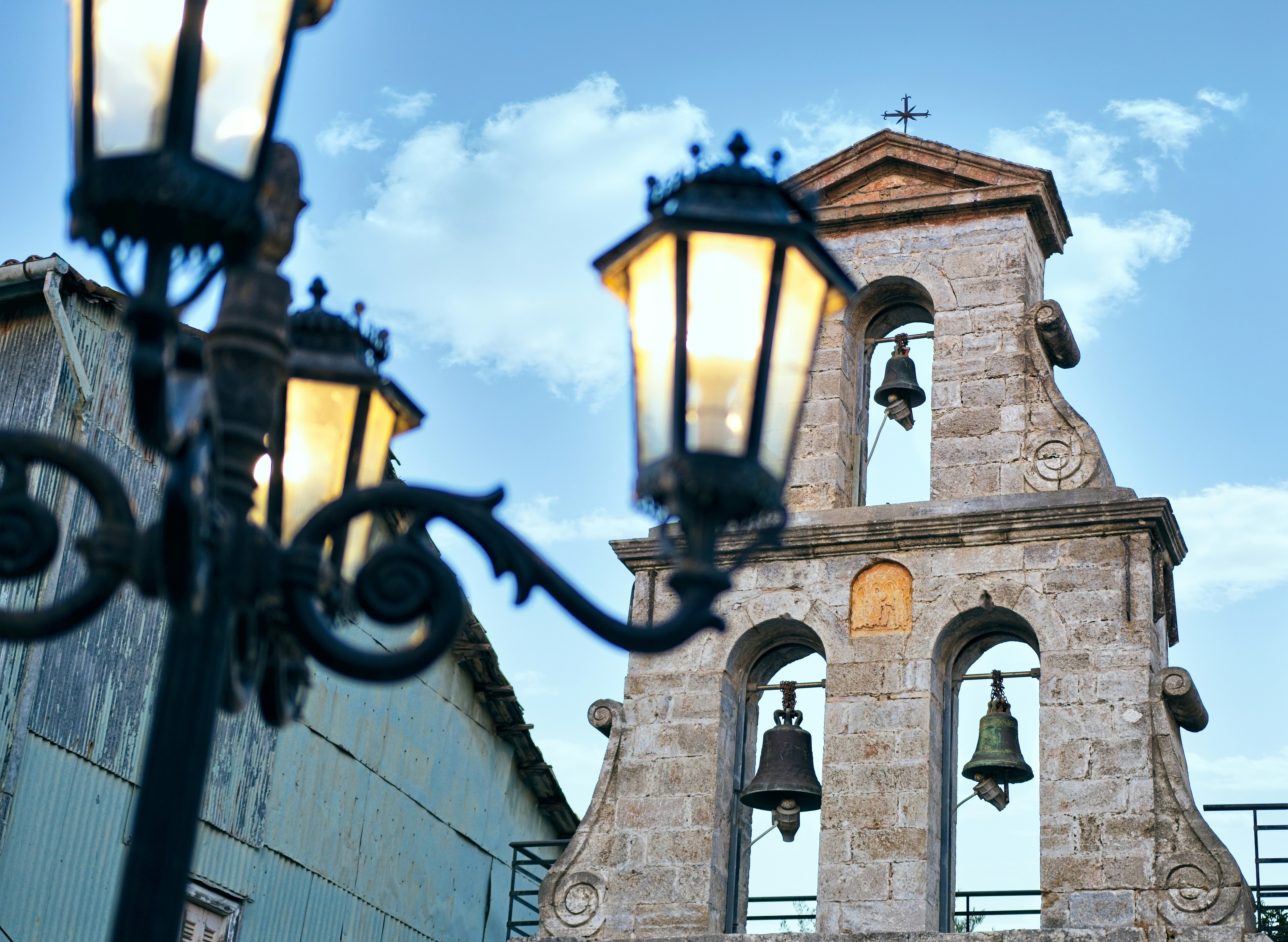 Bell tower is framed by an ornate lamppost.