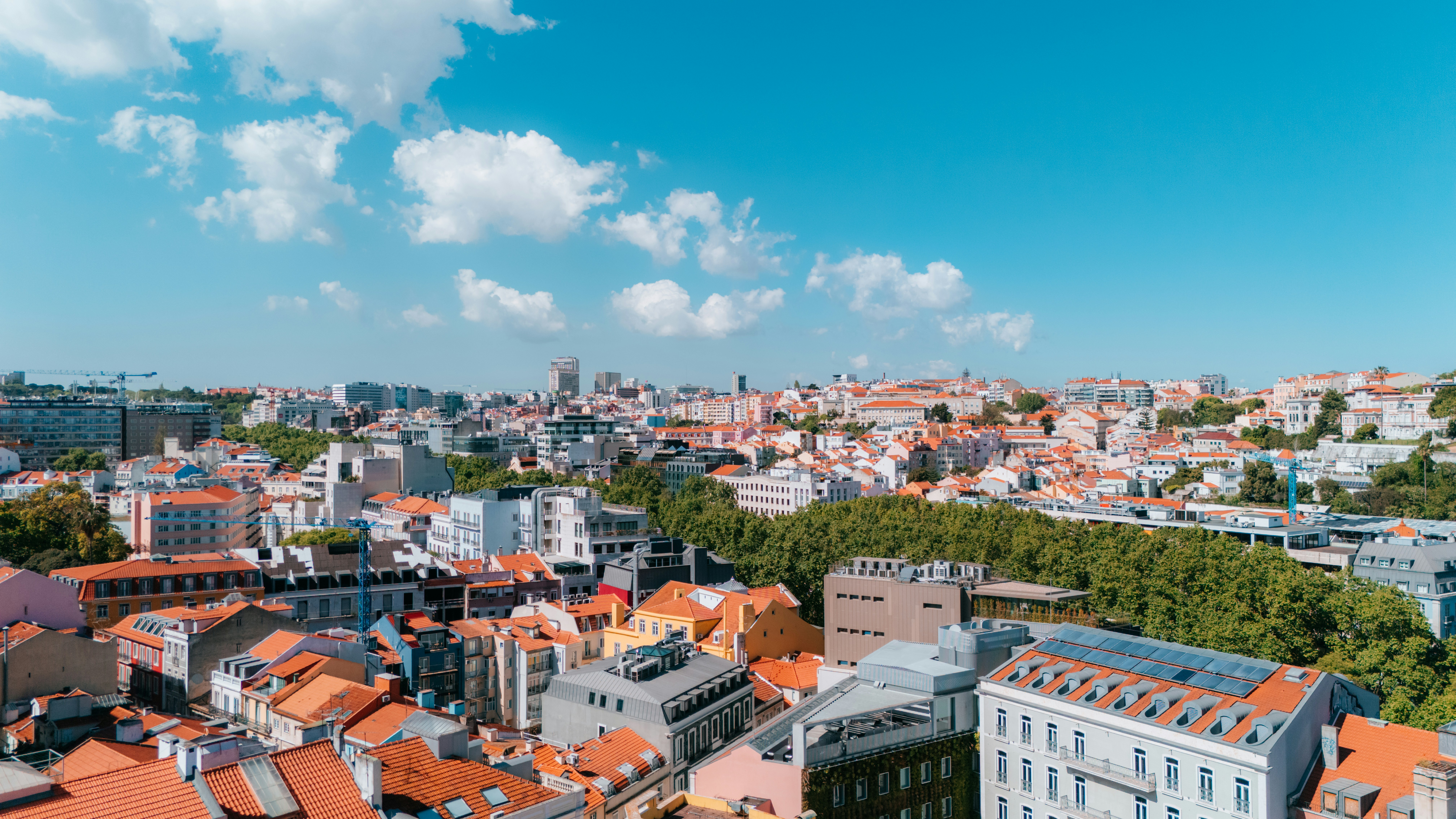 Aerial view of a city under a bright blue sky.