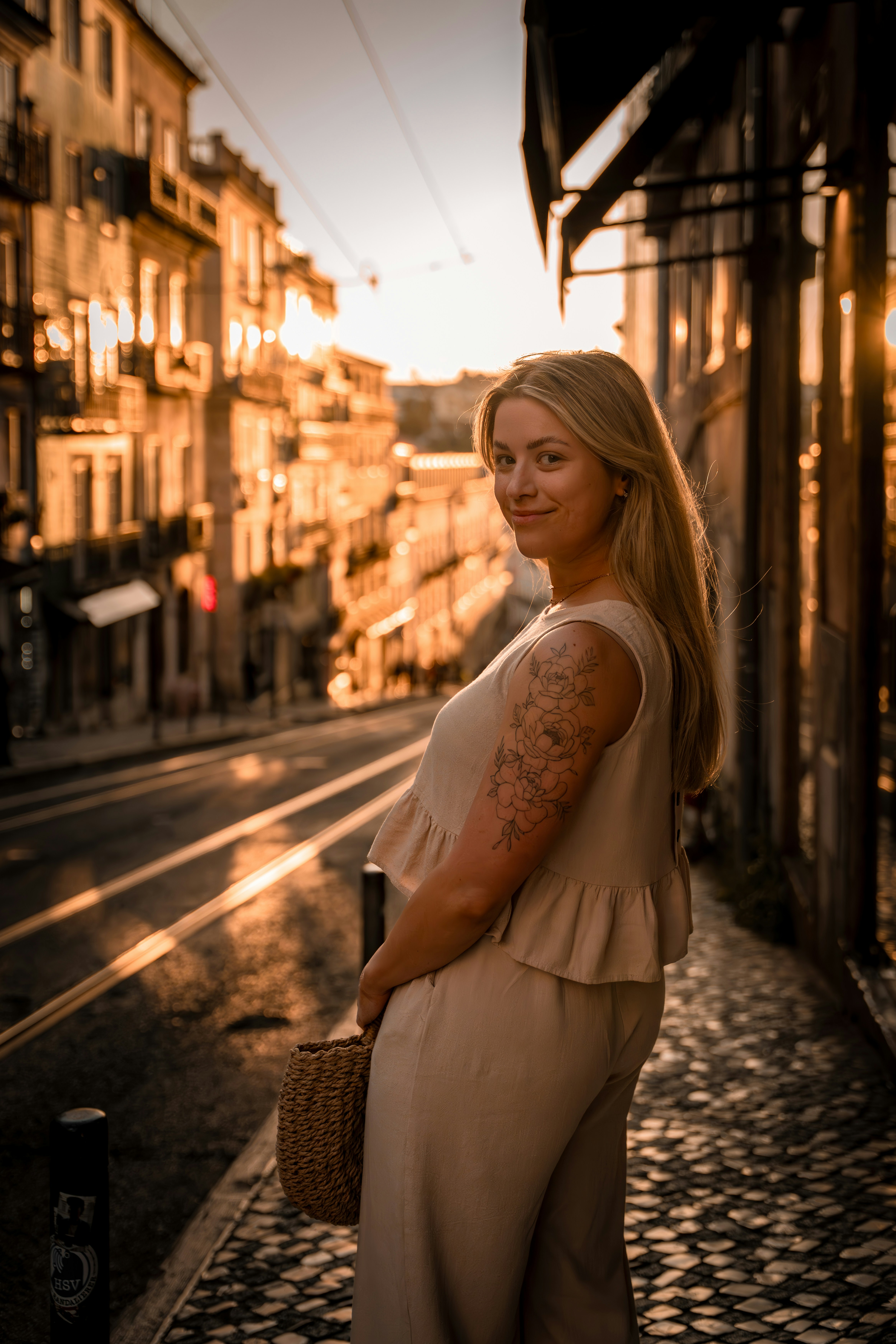 Woman poses on a sunlit european street.