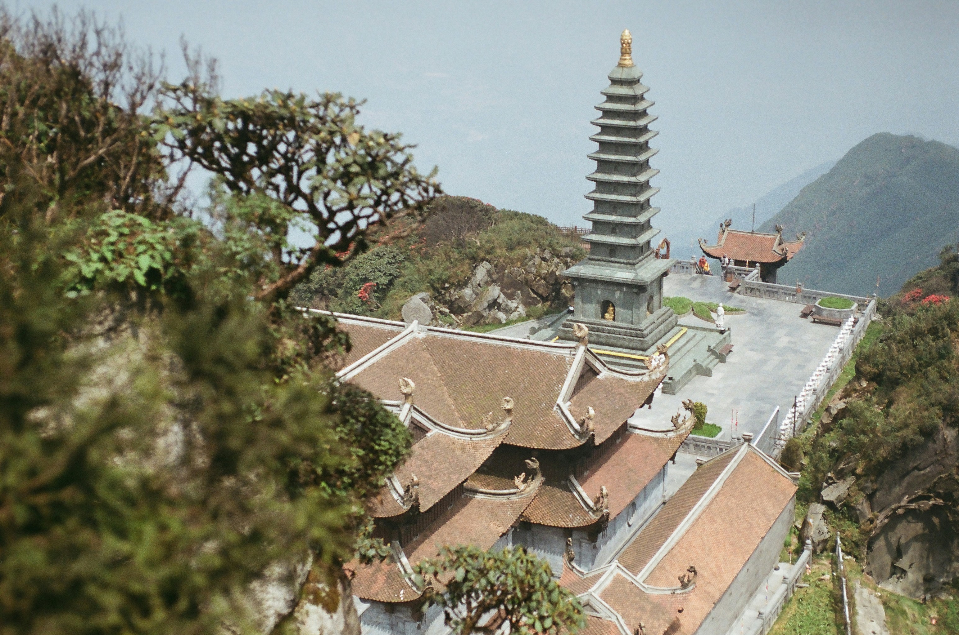 A temple perched atop a lush, mountainous landscape.
