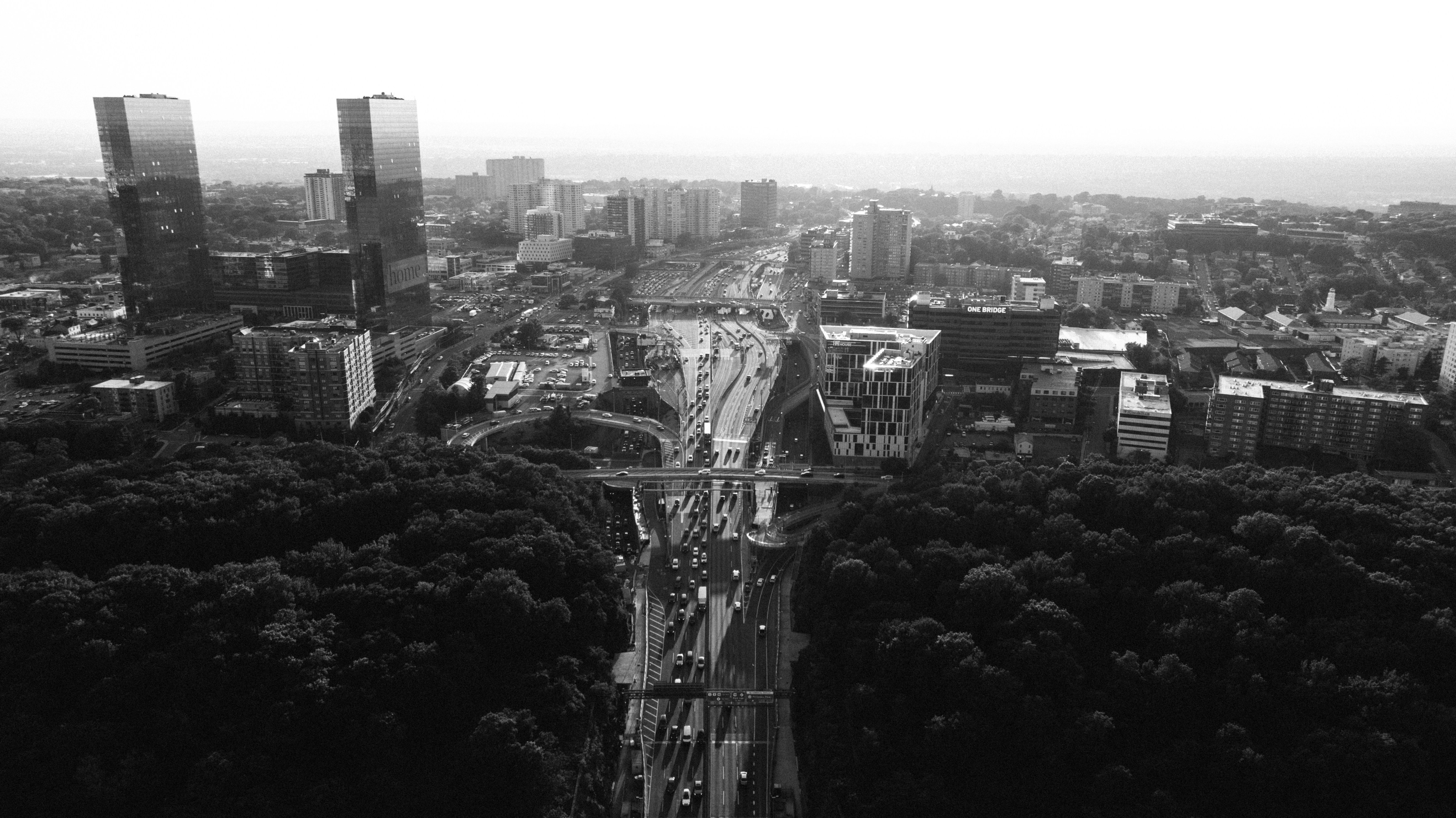 A black and white cityscape with highways and skyscrapers.