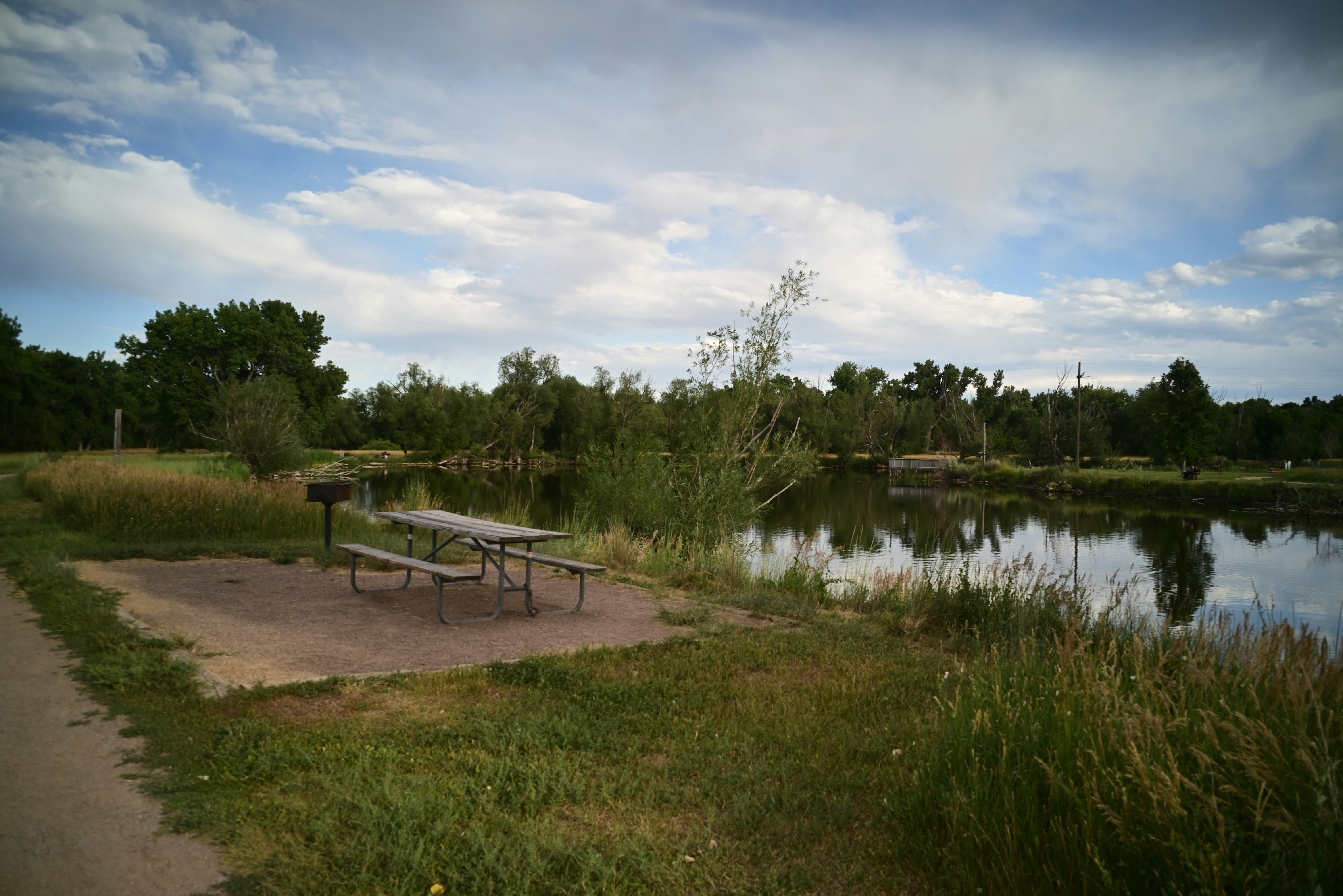 A picnic area sits next to a calm lake.