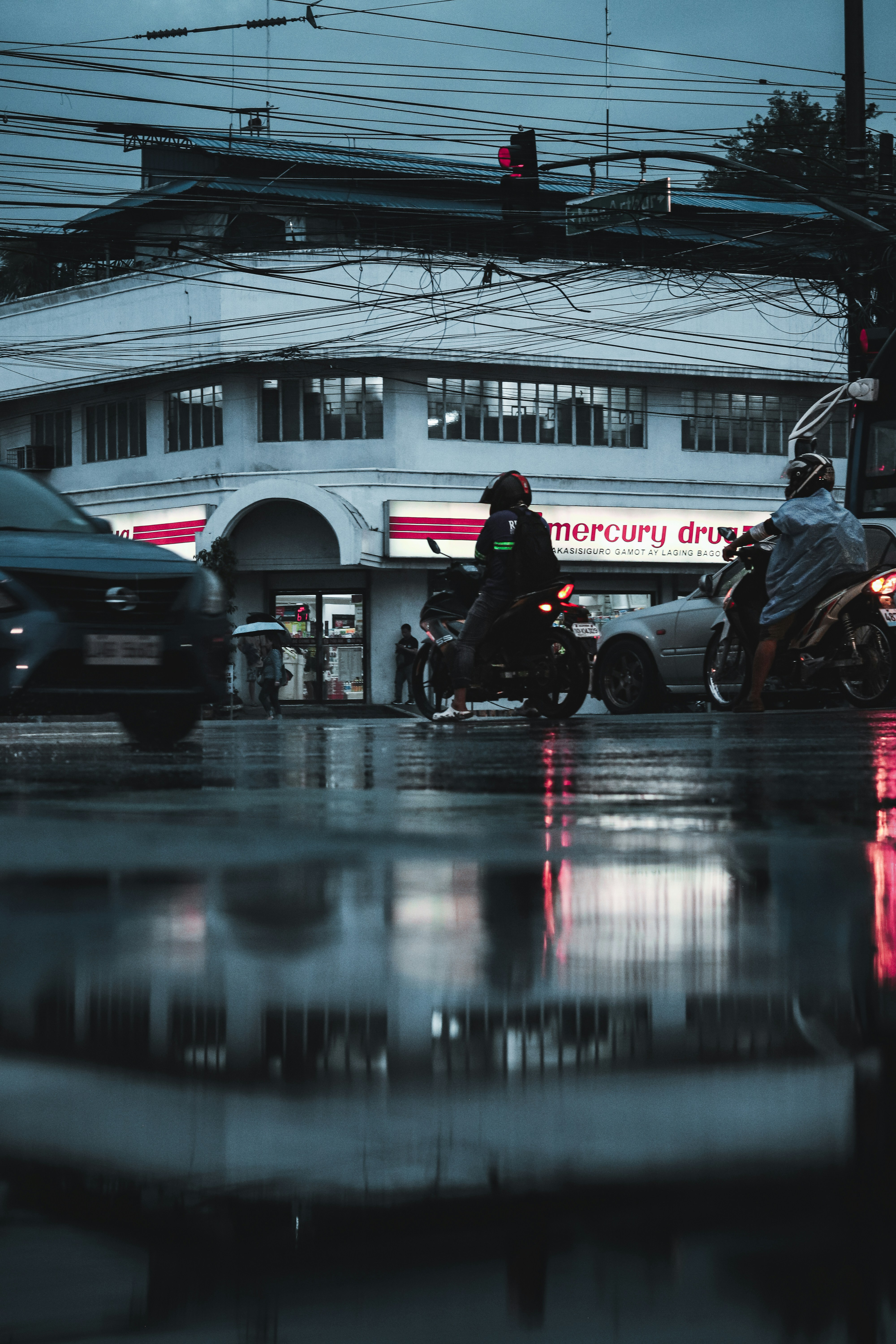 Rainy day street scene with vehicles.