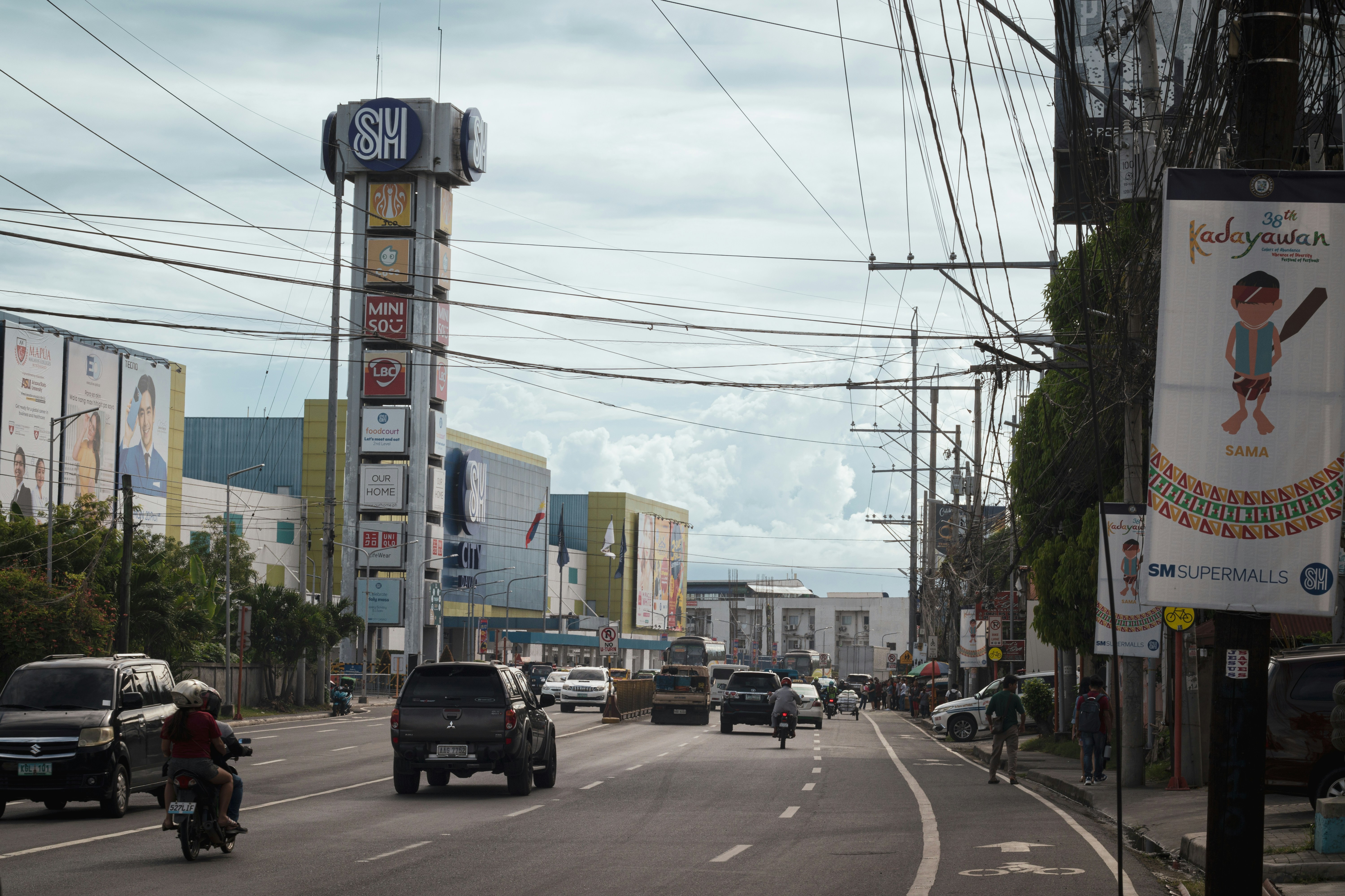 A busy road features buildings and power lines.