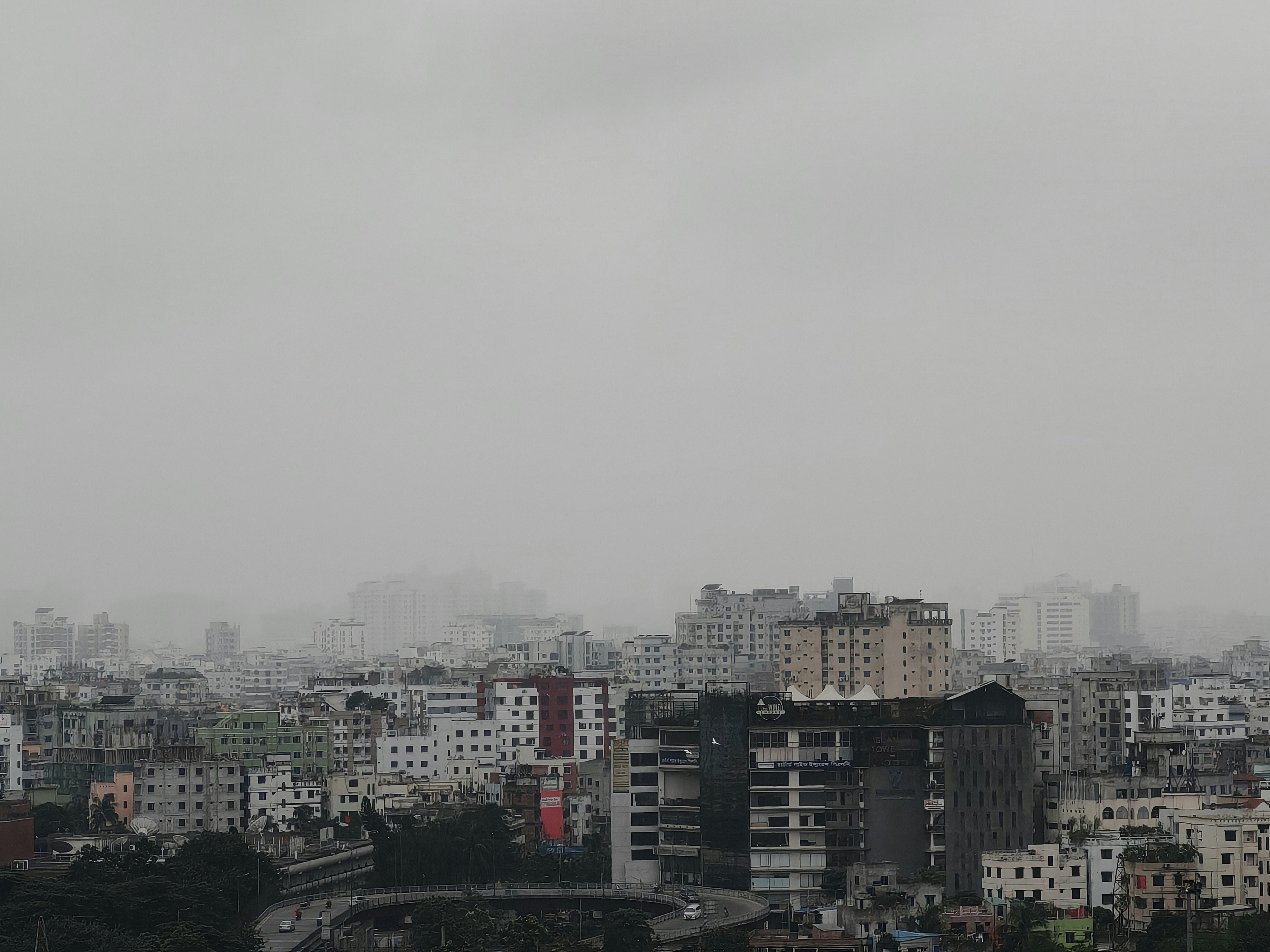 Cityscape shrouded in mist and overcast skies.