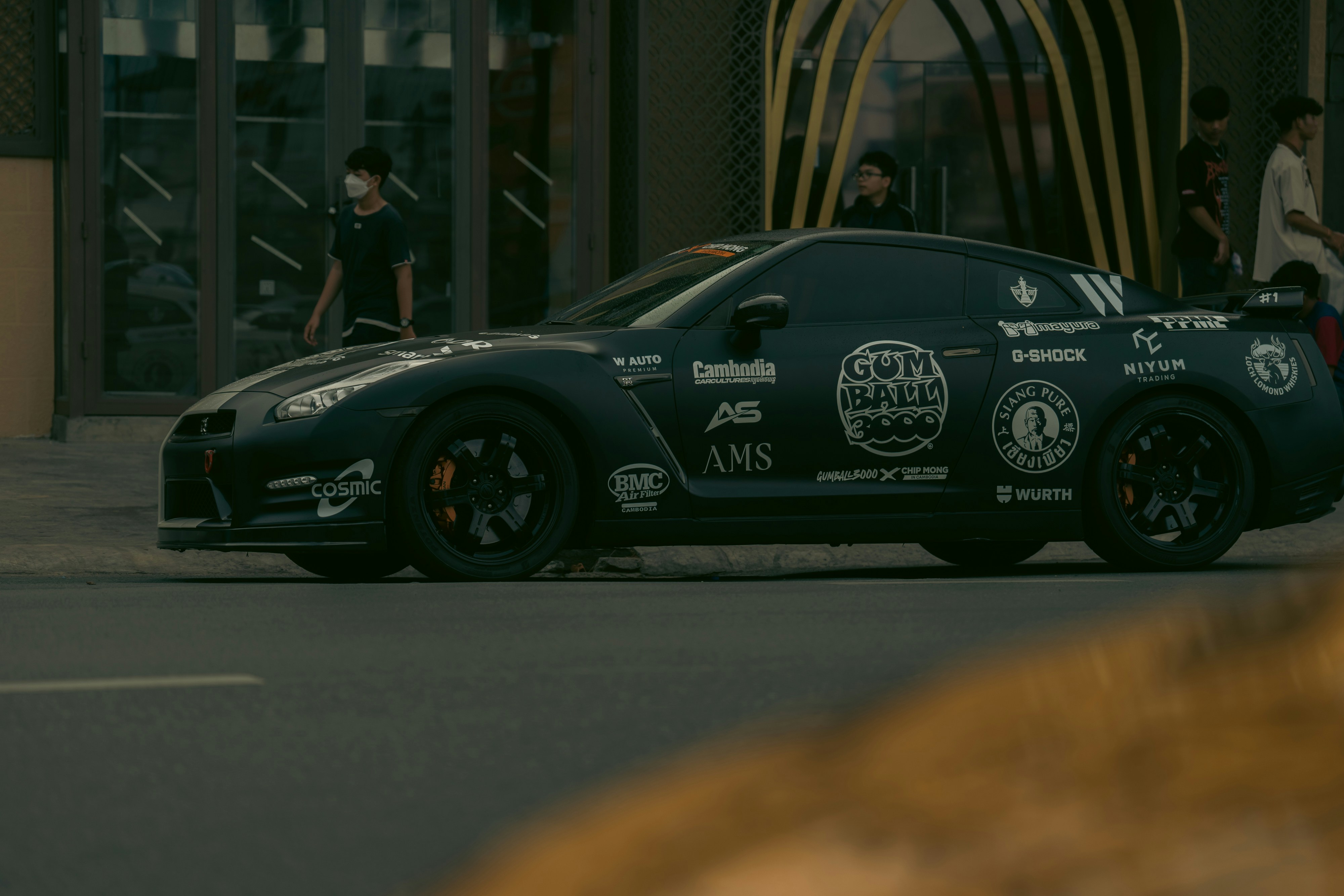 A black nissan gt-r with many stickers.