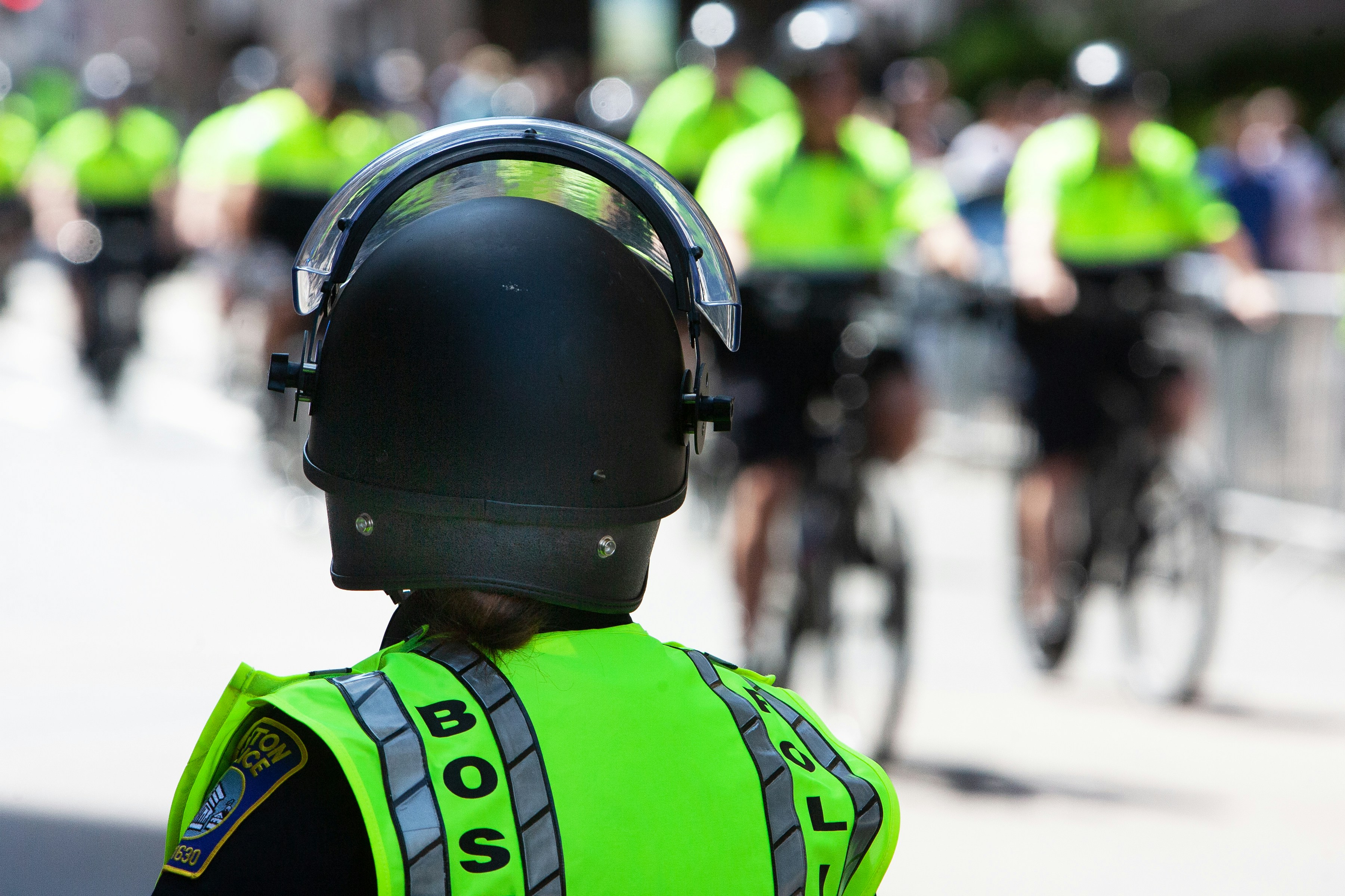 Police officers on bicycles are wearing safety gear.