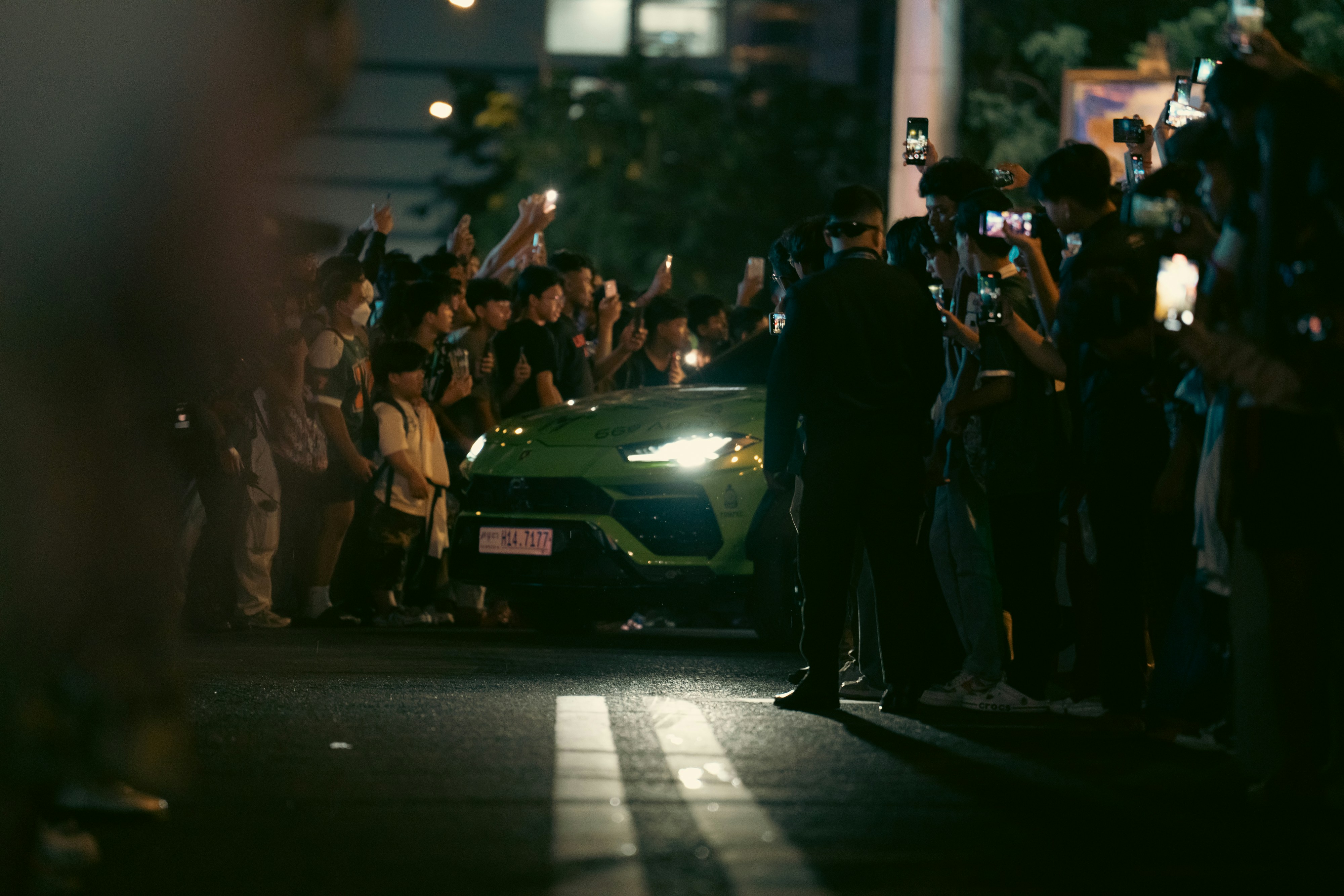 Fans surround a green lamborghini.
