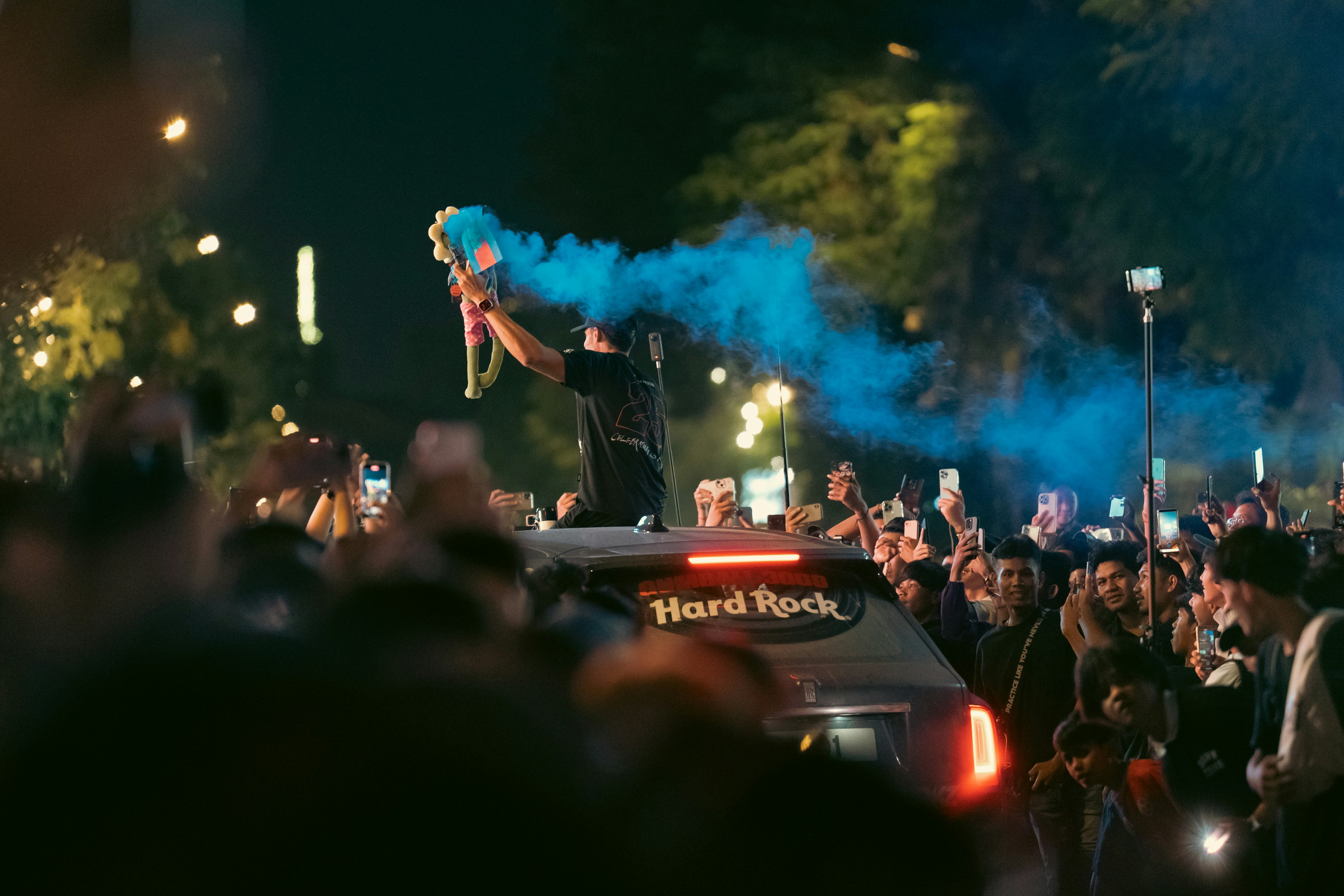 Fans celebrate with a flare during a night celebration.