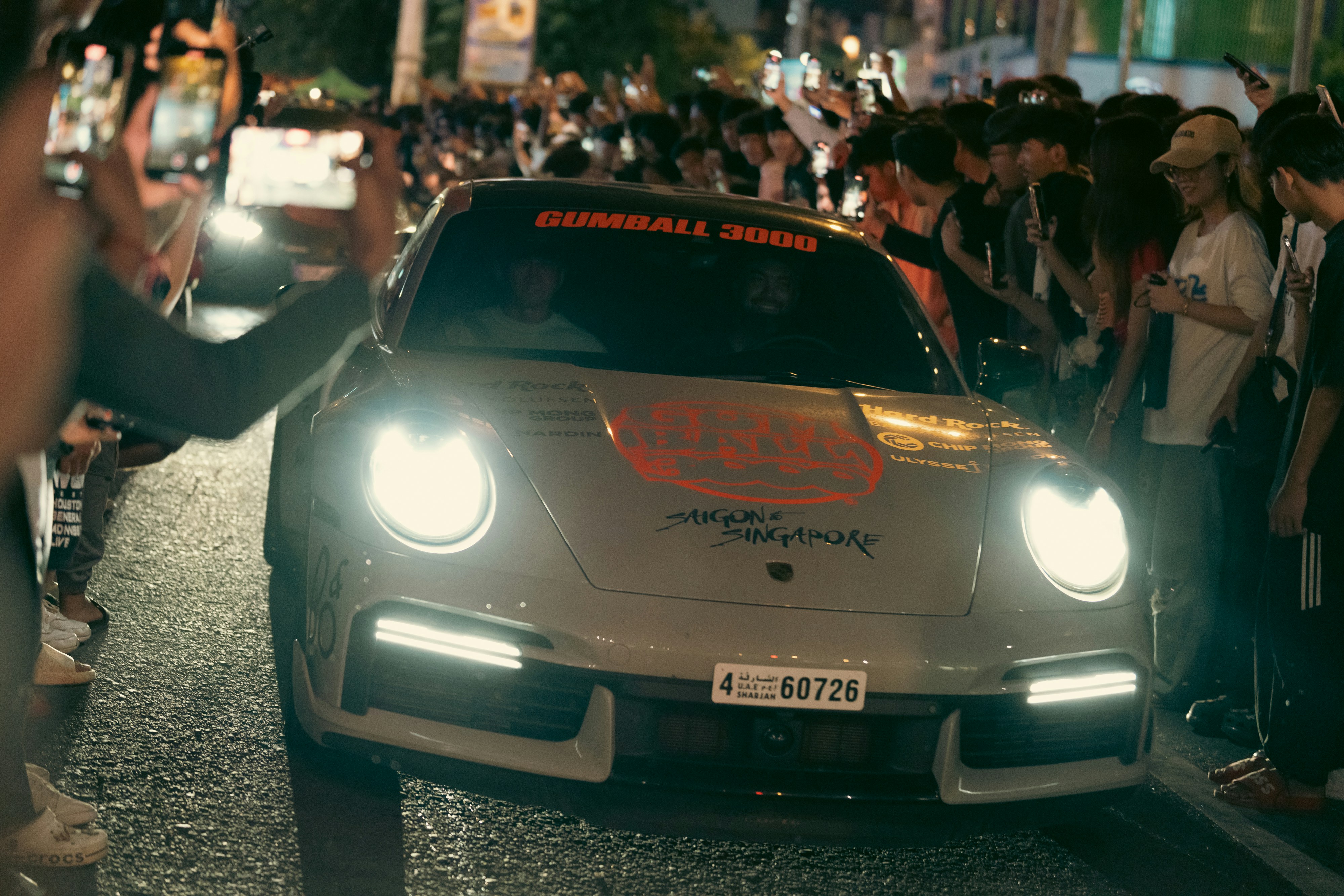 A porsche car is surrounded by a crowd.
