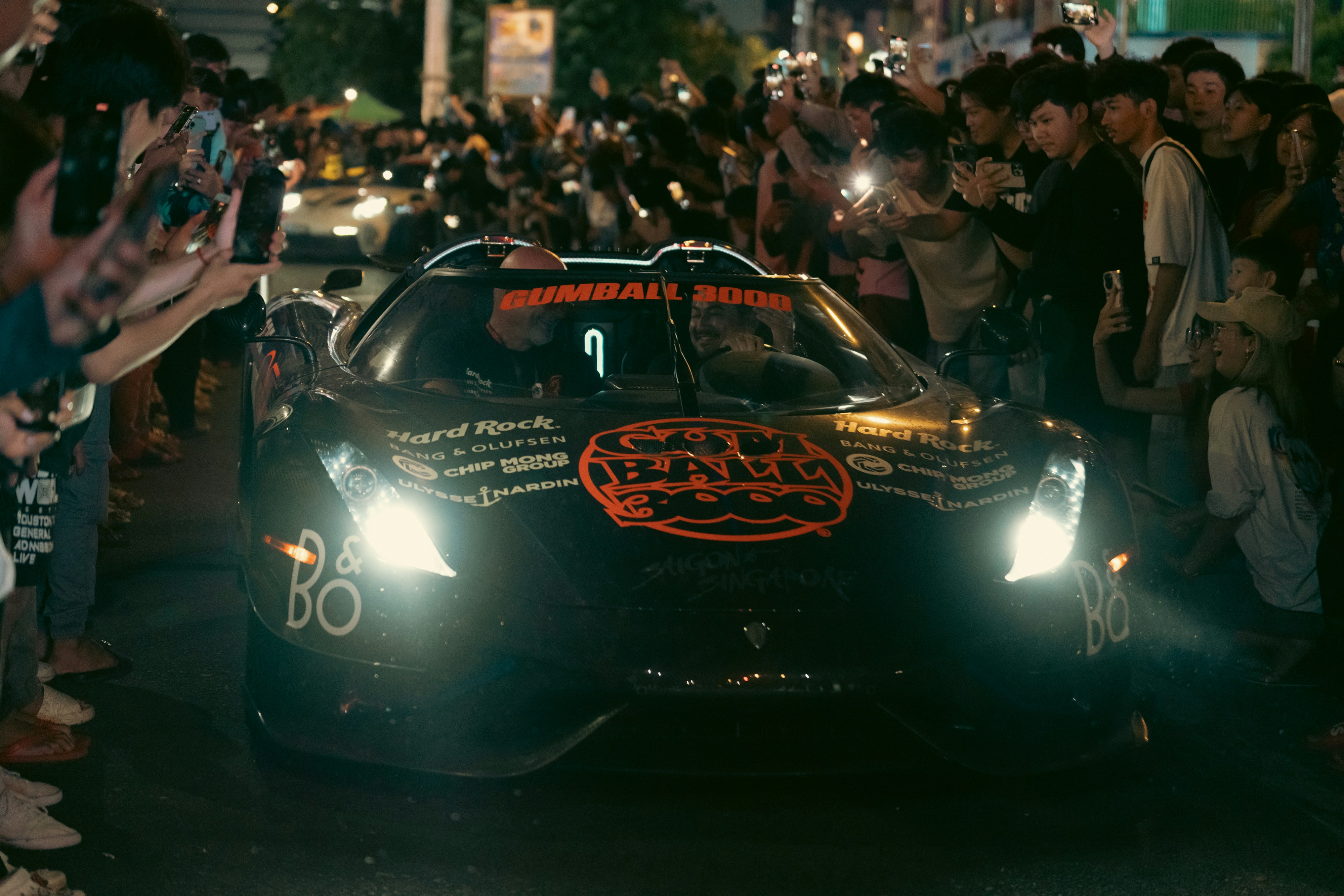 A racing car drives through a cheering crowd. photo – Free Car Image on ...