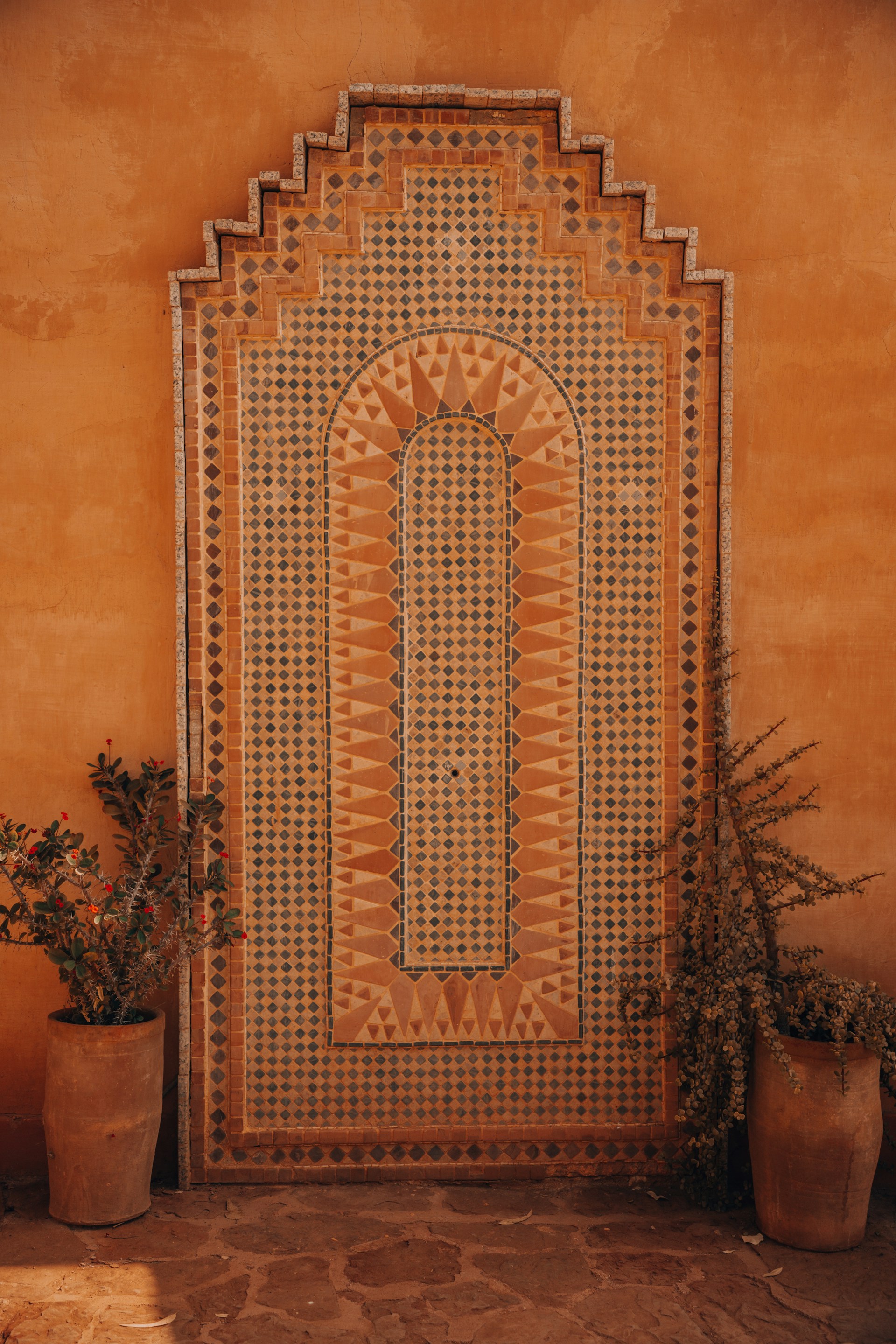 Moroccan tile artwork with plants.