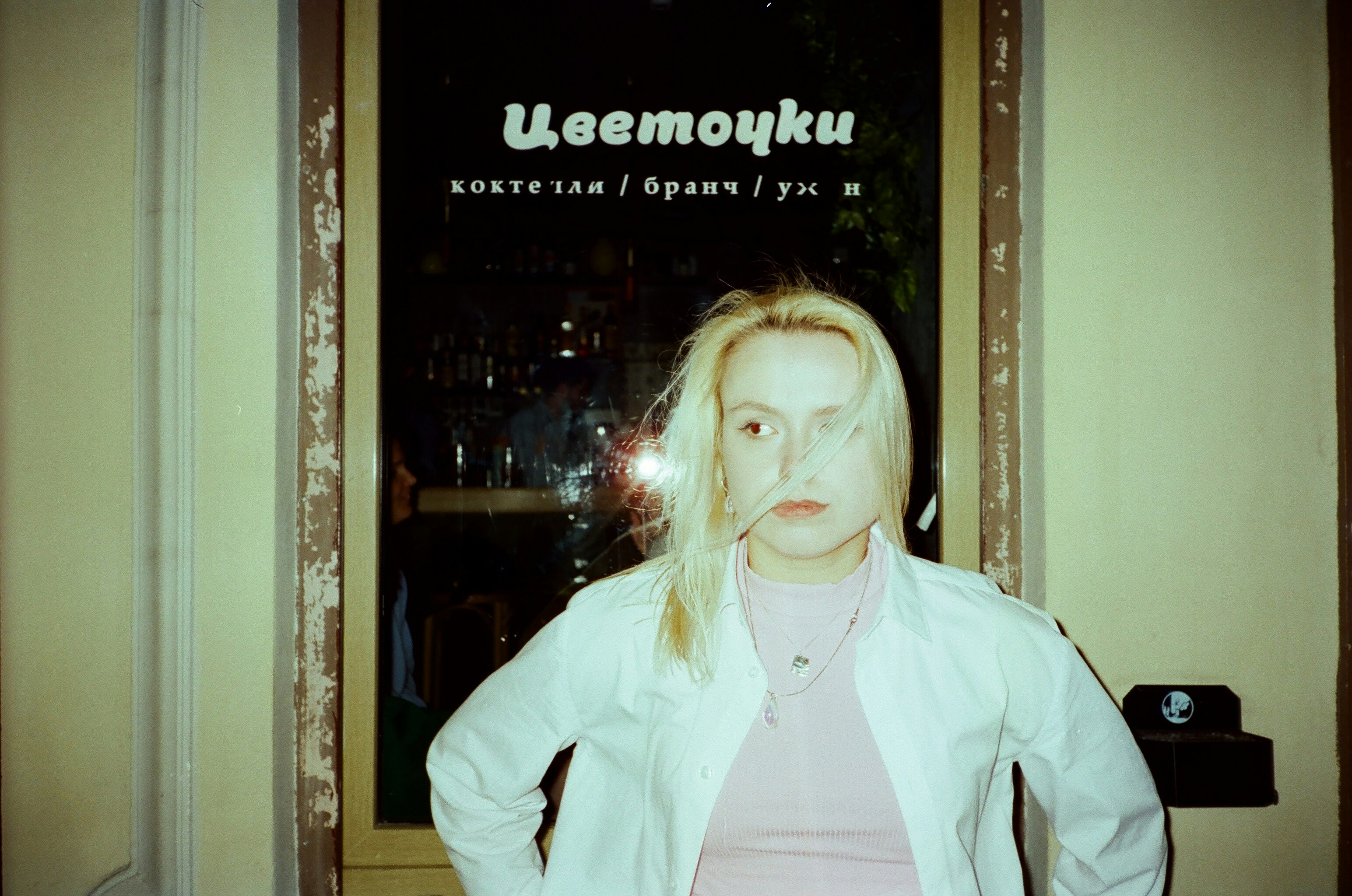 Une femme se tient devant une fenêtre.