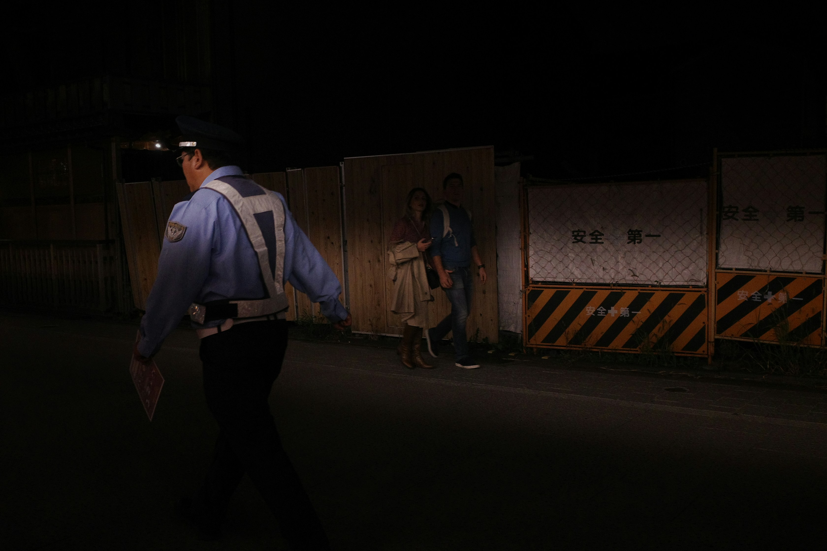 A police officer approached a confrontation at night.