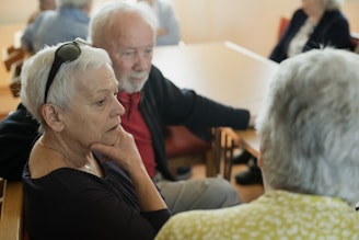 Elderly people are sitting and talking with each other.