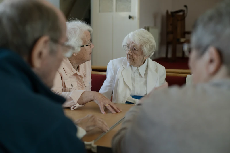 Seniors enjoying friendly conversation together around a table