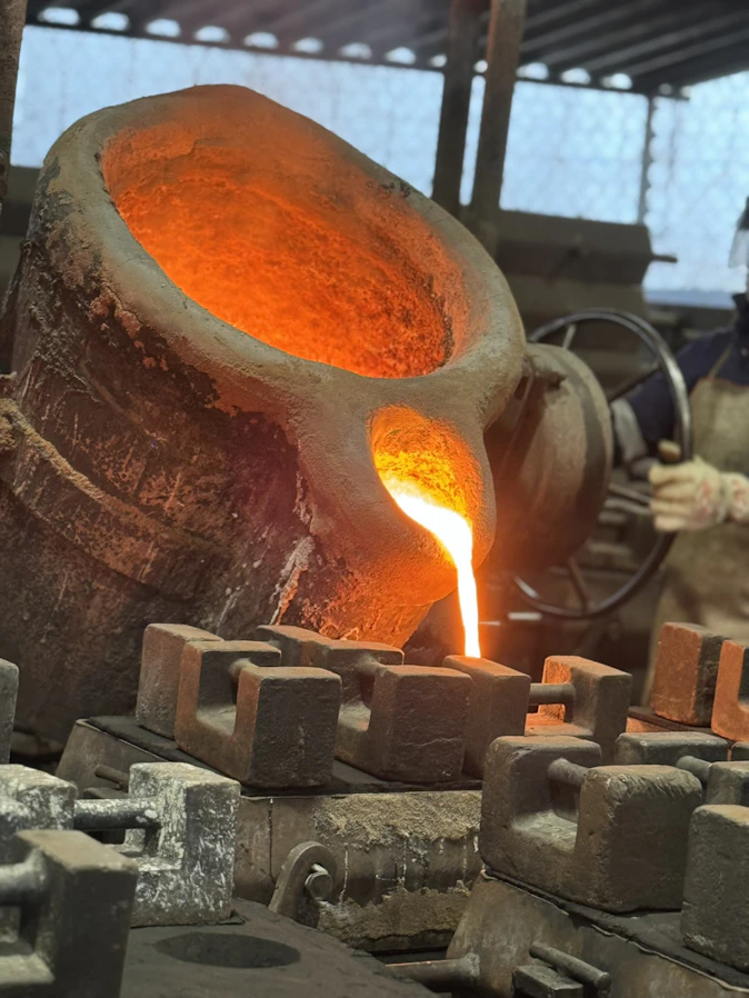 Molten metal is being poured into molds.