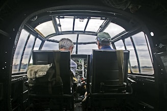 Pilots sit inside the cockpit of an airplane.
