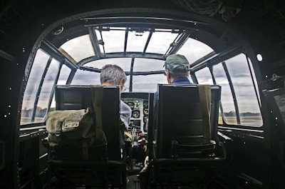 Pilots sit inside the cockpit of an airplane.