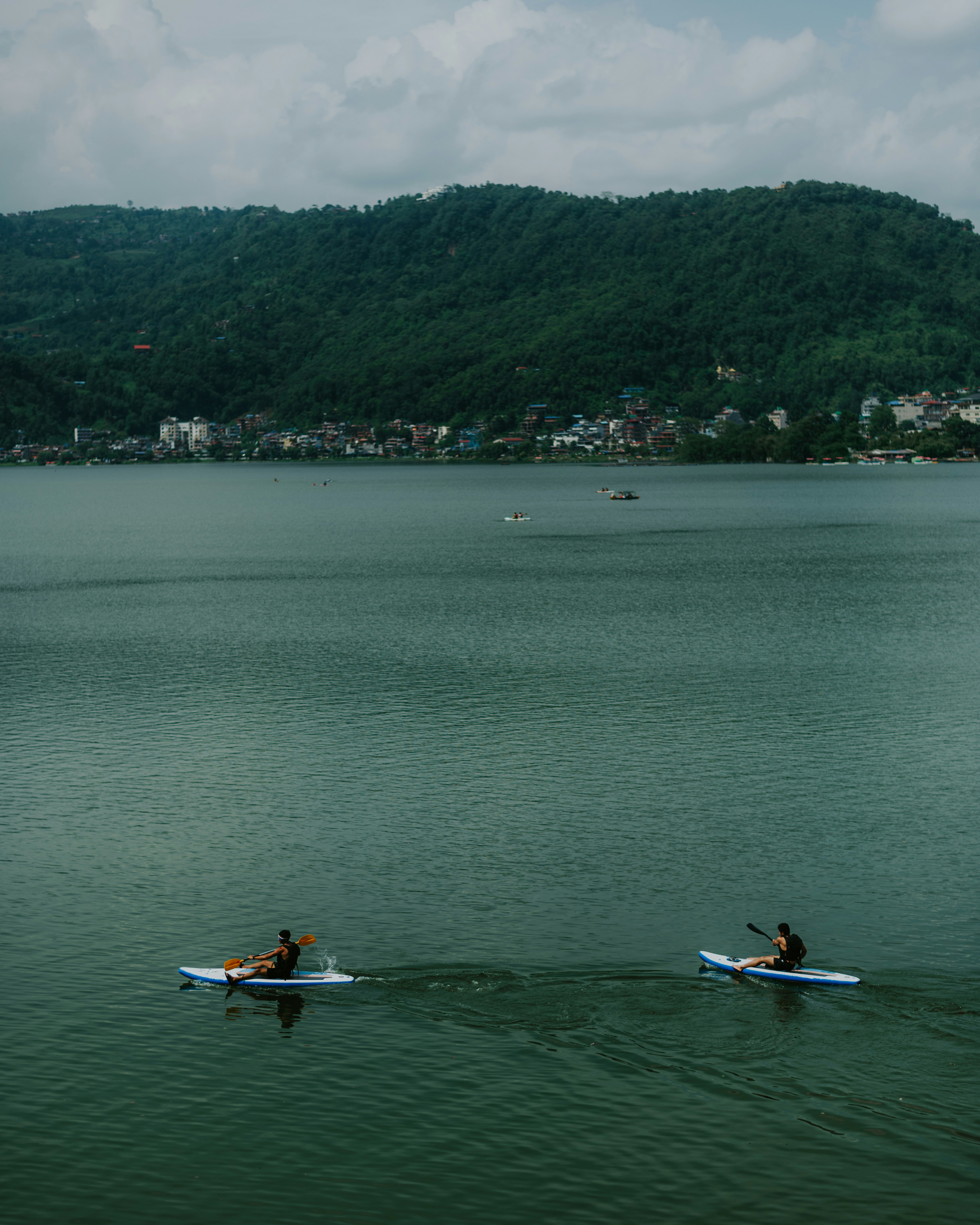 People paddleboarding on a calm lake.