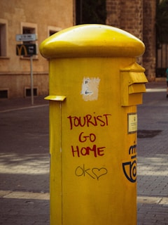 Yellow mailbox with anti-tourist graffiti about Mallorca overtourism