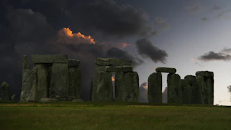 Stonehenge stands beneath a dramatic, stormy sky.