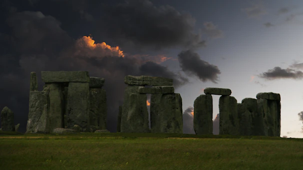 Stonehenge stands beneath a dramatic, stormy sky.
