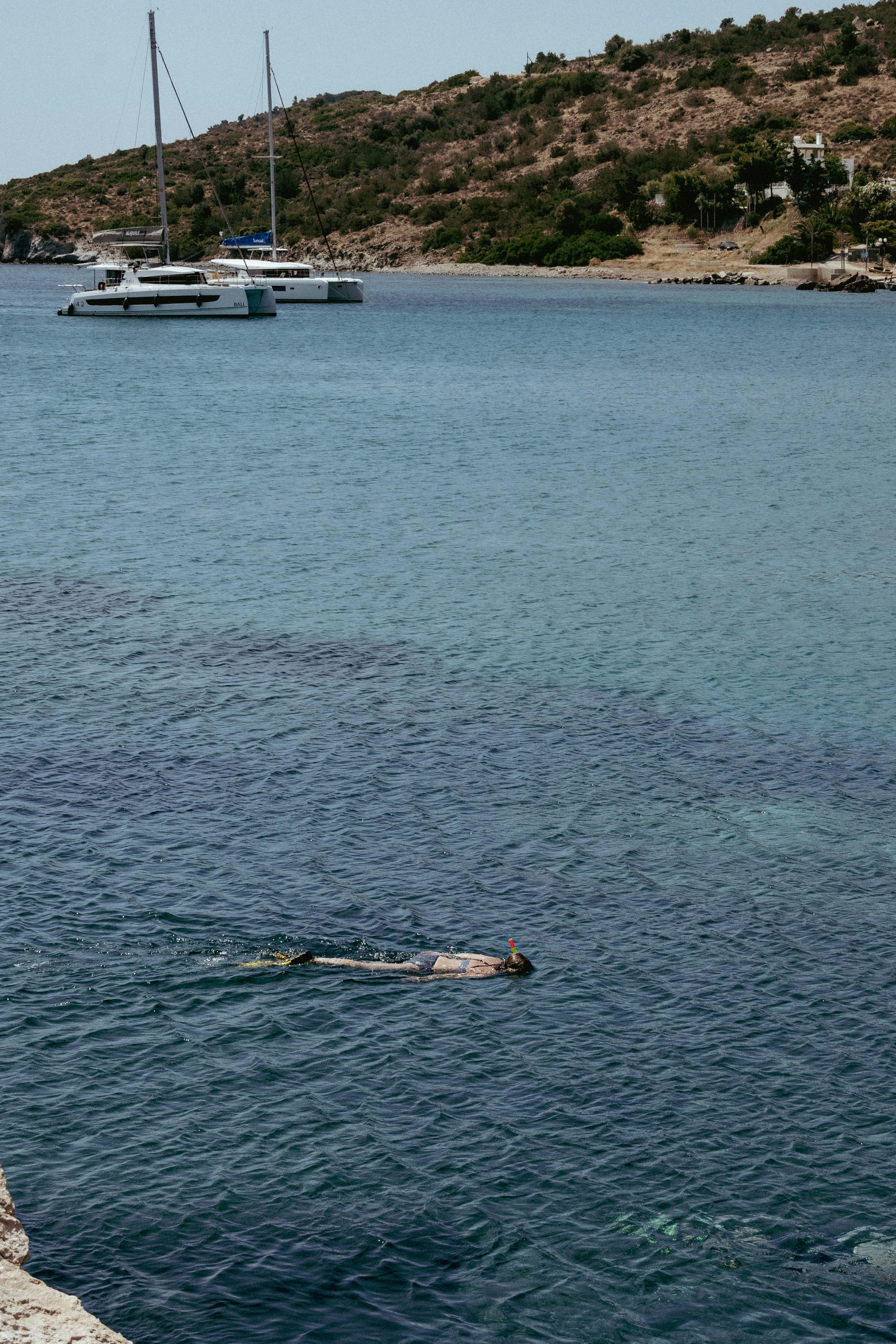 A person snorkels in clear blue waters.