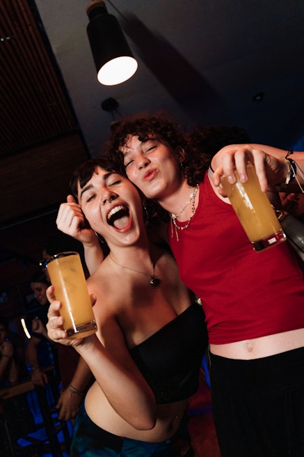 Two friends have drinks and are celebrating.